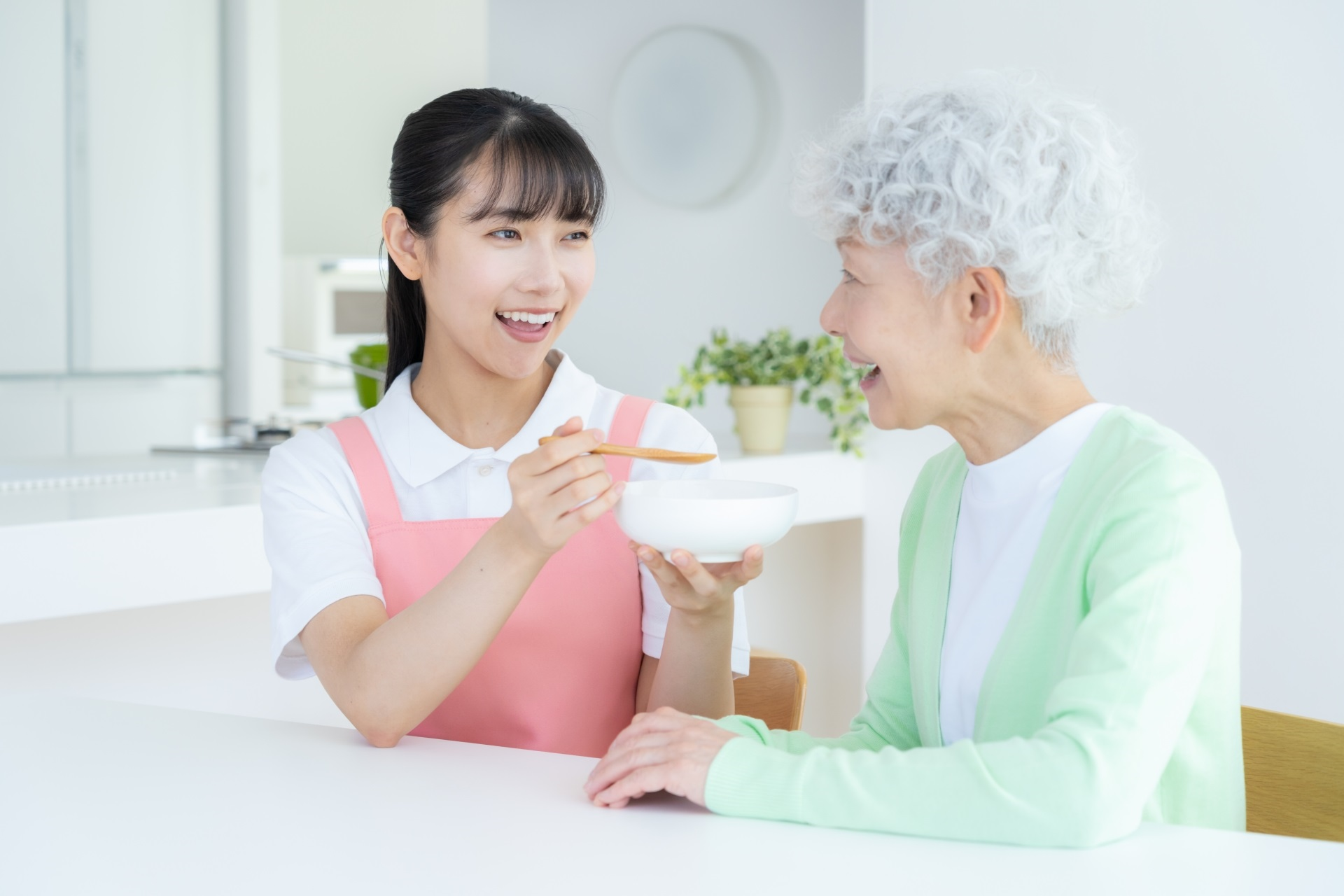 食事を食べさせる介護士の女性