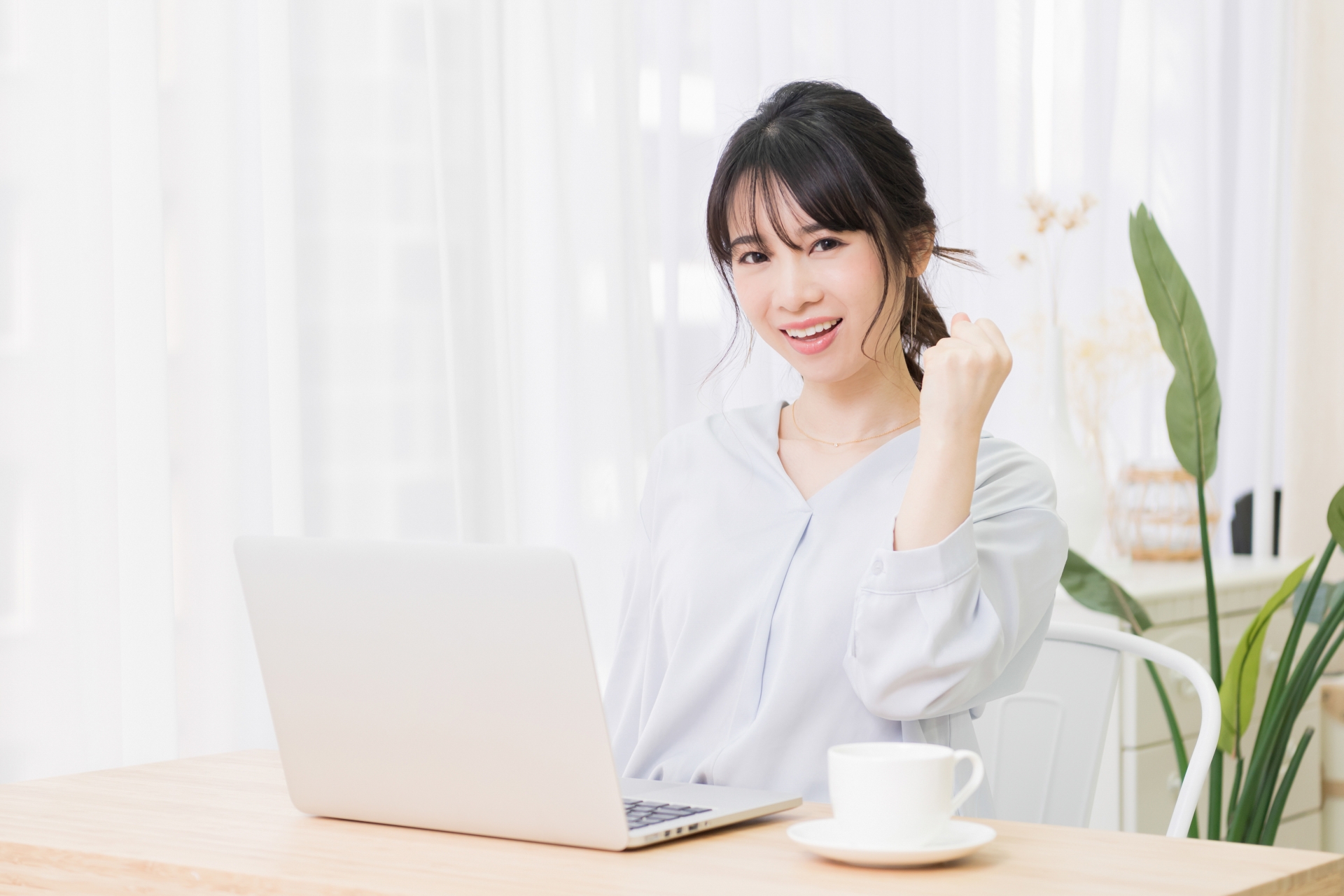 ガッツポーズをする若い女性