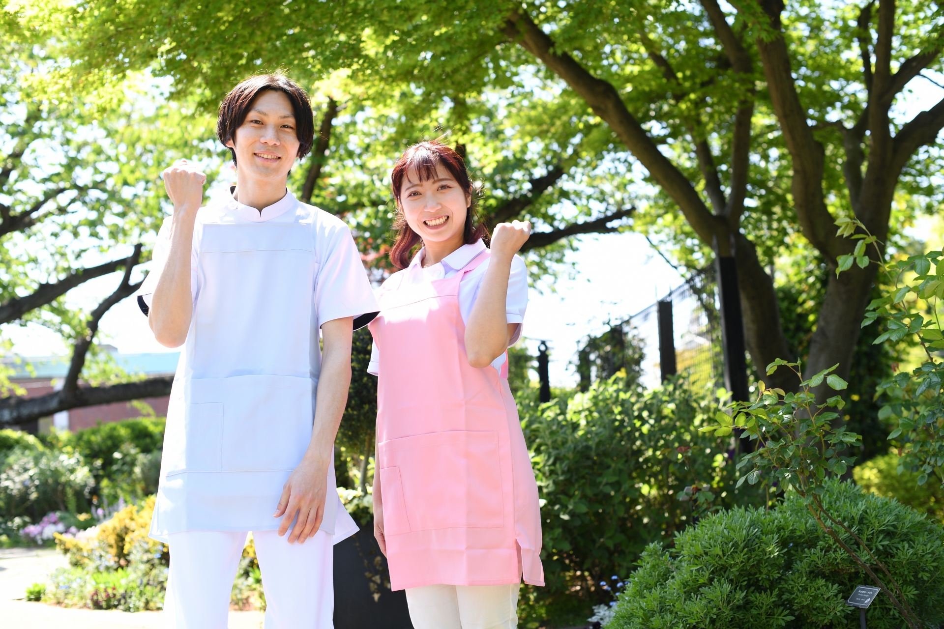 ガッツポーズをするエプロン姿の男女