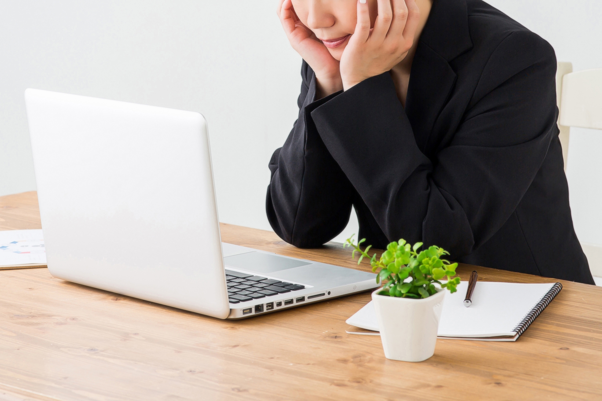 肘をついてパソコン画面を見る人