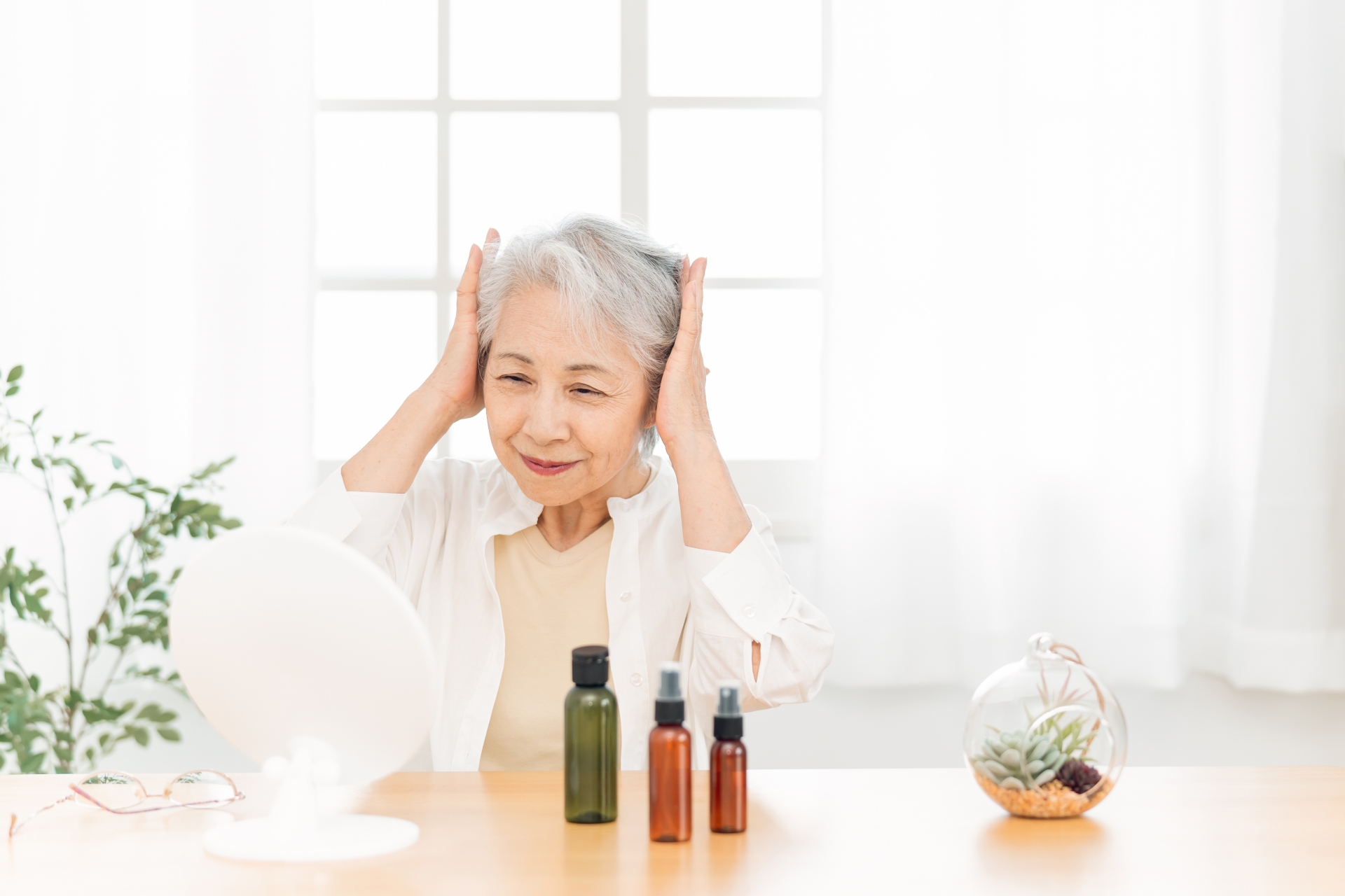 髪の毛をセットする高齢者女性