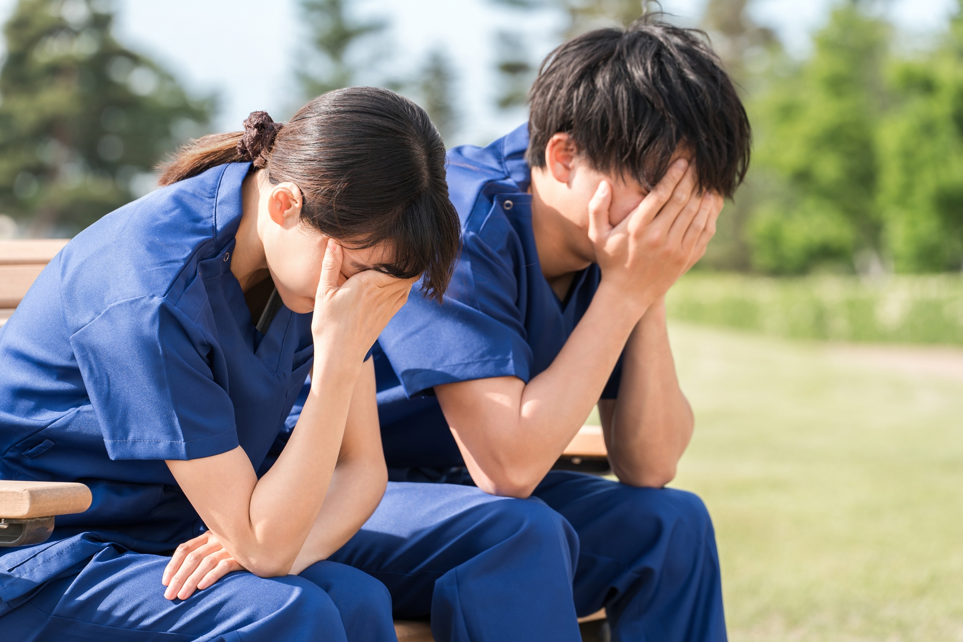 ベンチに座り落ち込む看護師