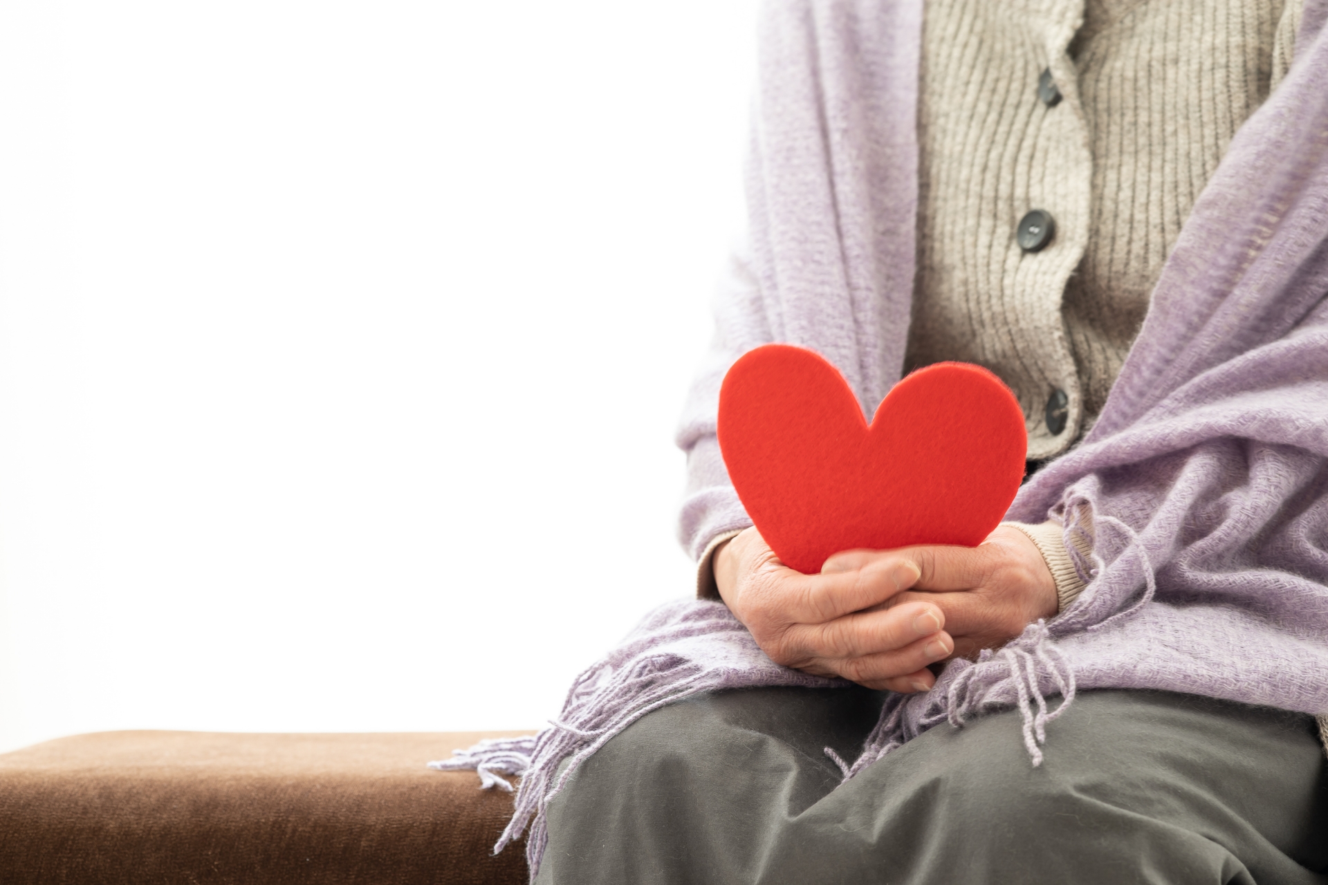 ハートを持って座っている高齢者