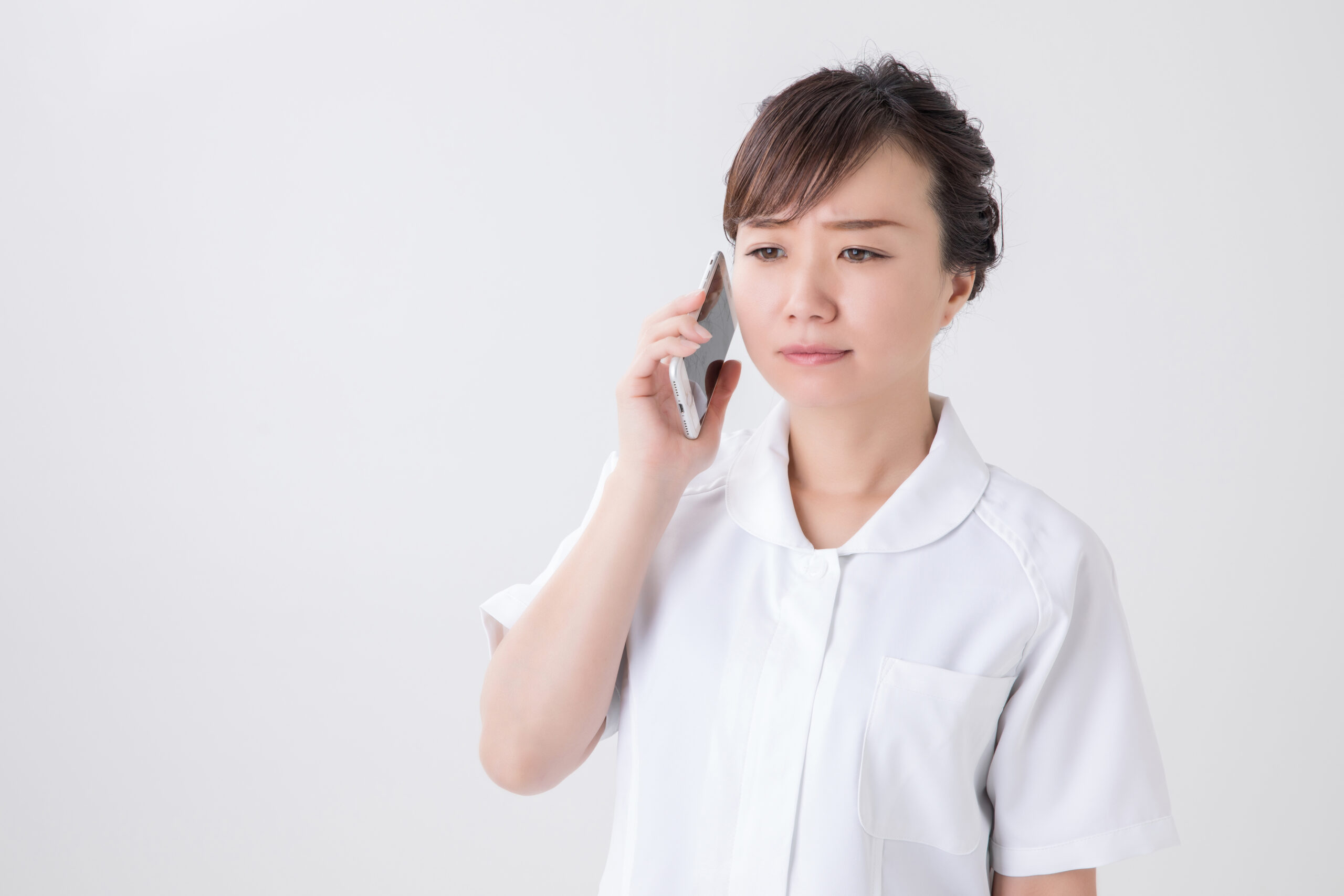 電話で困る白衣の女性