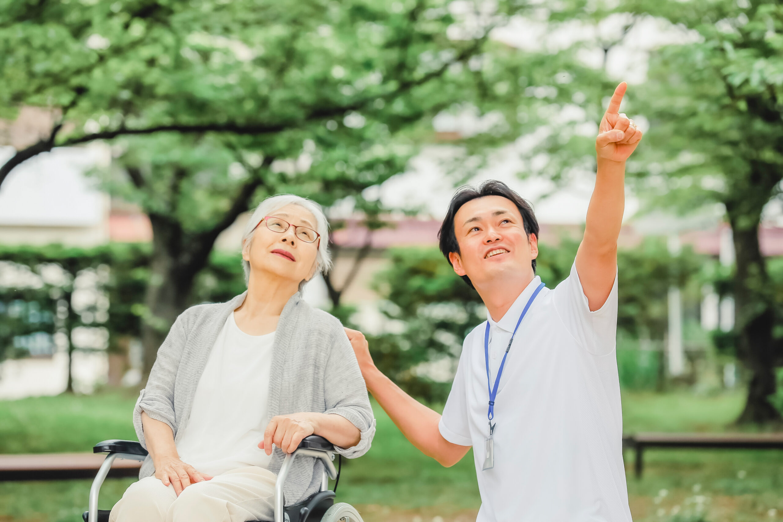 車椅子に乗った高齢者女性と男性スタッフ