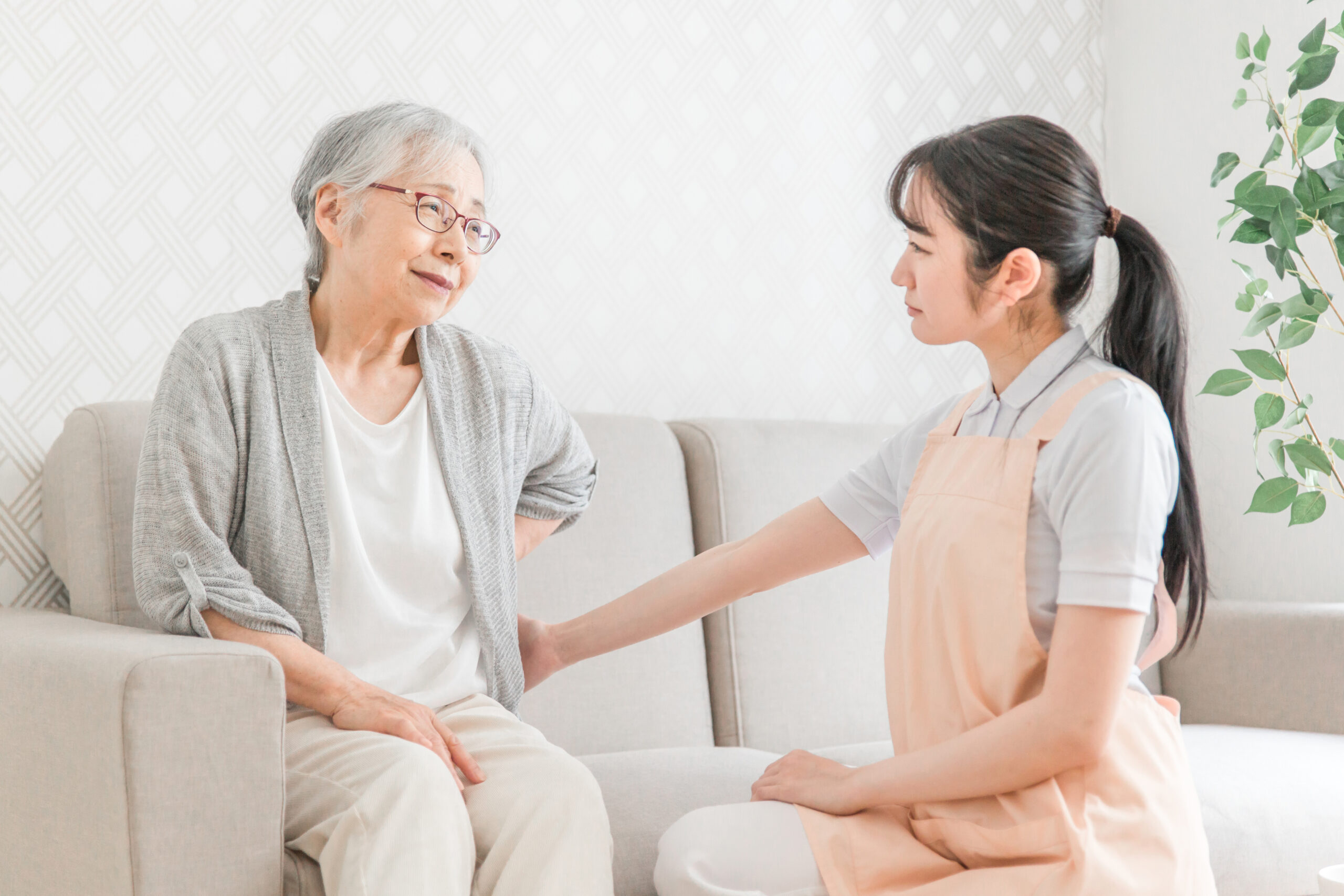 訪問介護・腰をおさえる高齢者女性