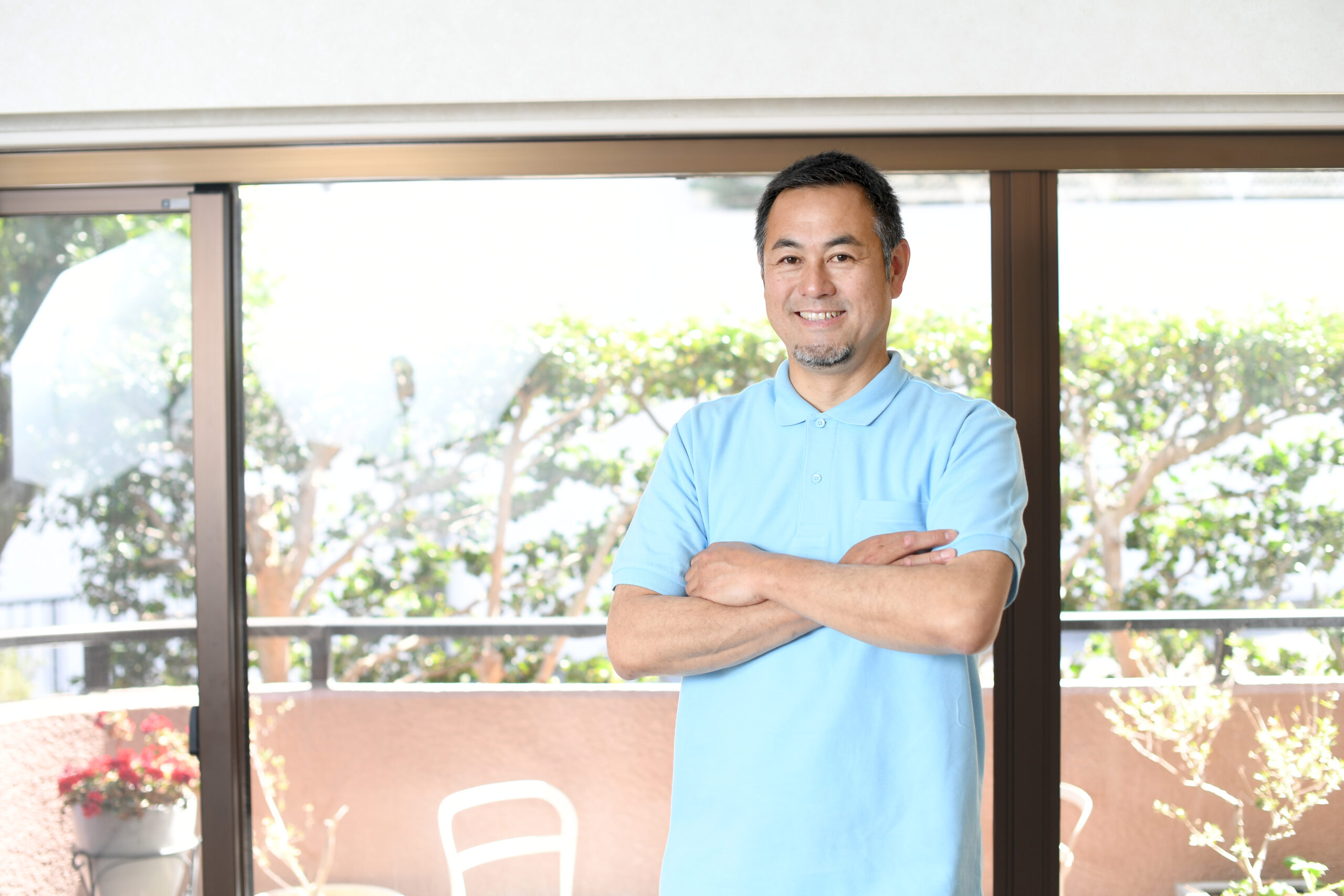 腕組みをする笑顔の男性介護士