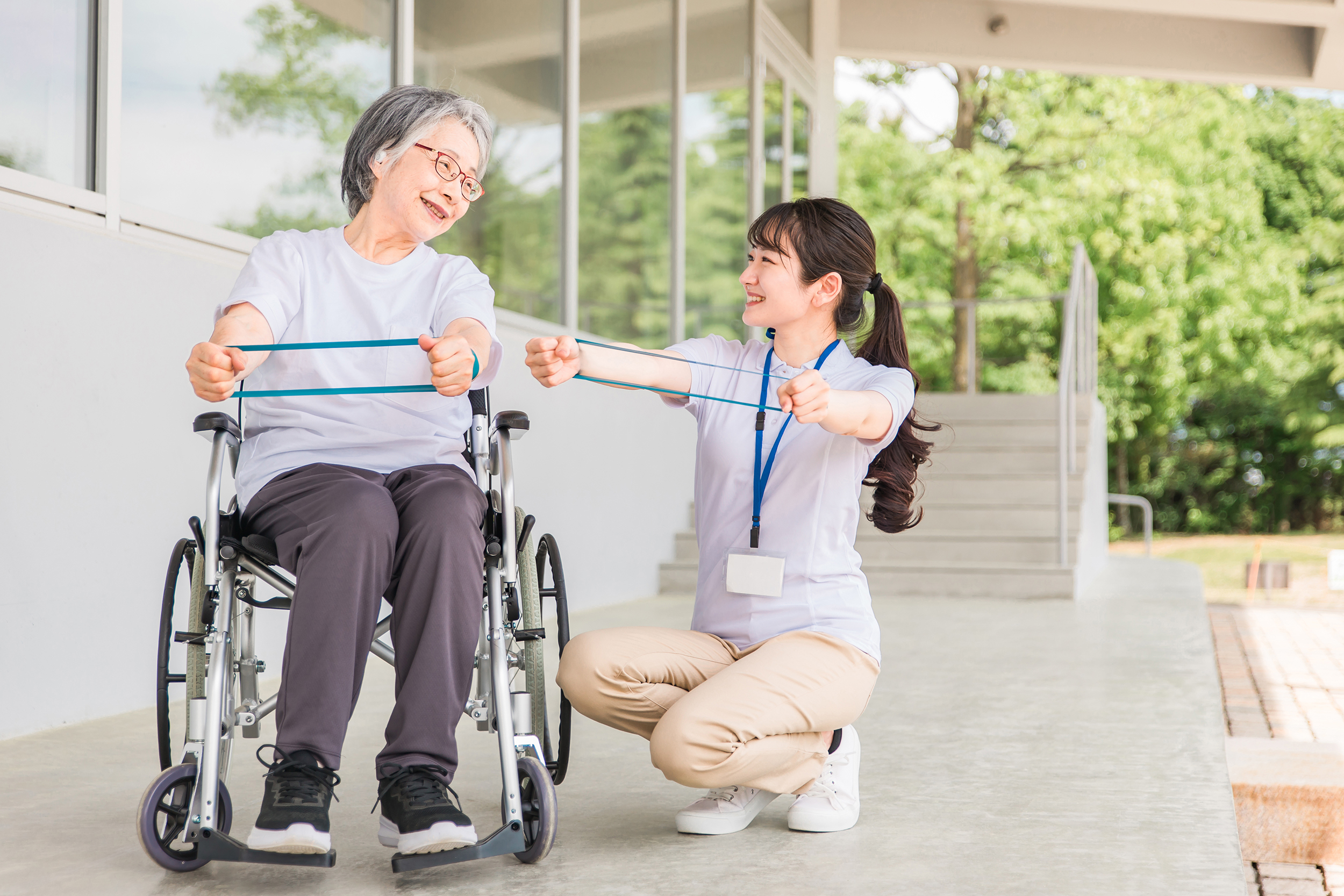 腕のリハビリをする高齢者女性と理学療法士