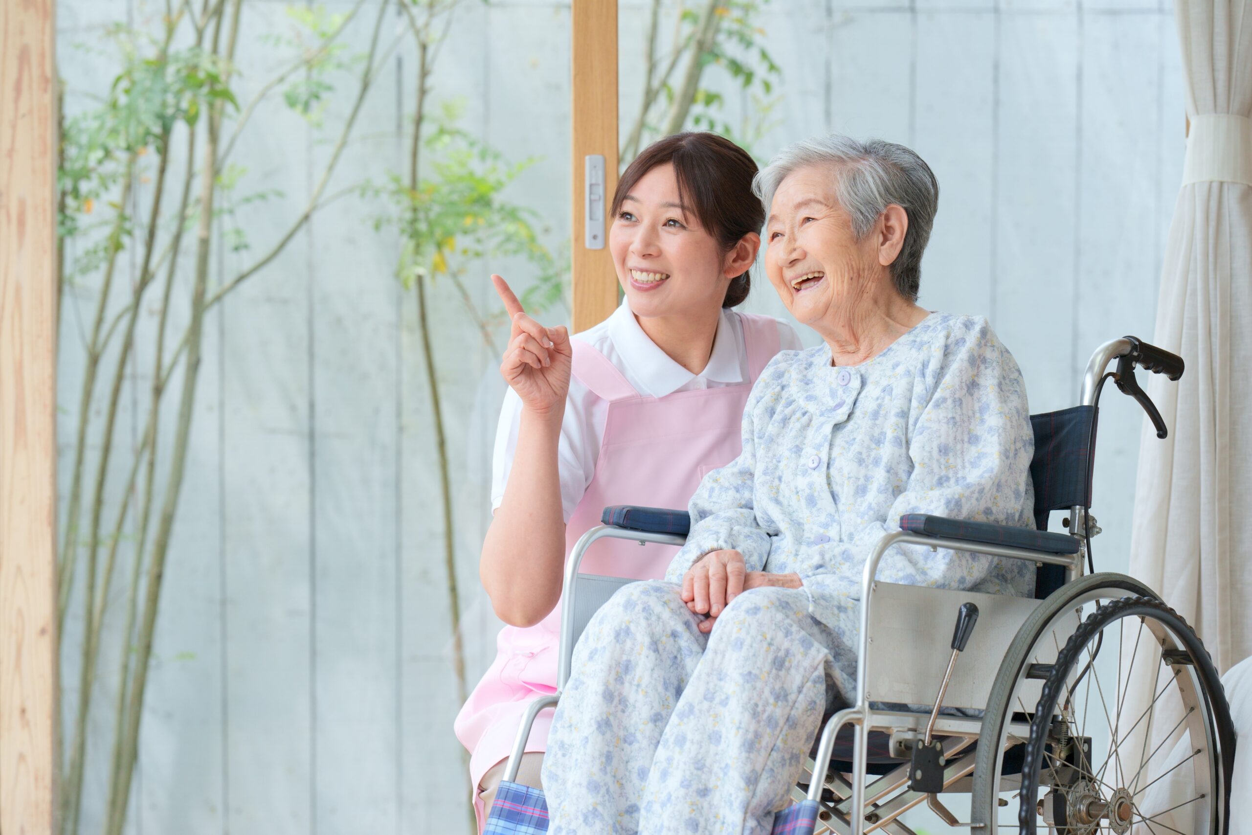 介護士と外を見る笑顔の女性
