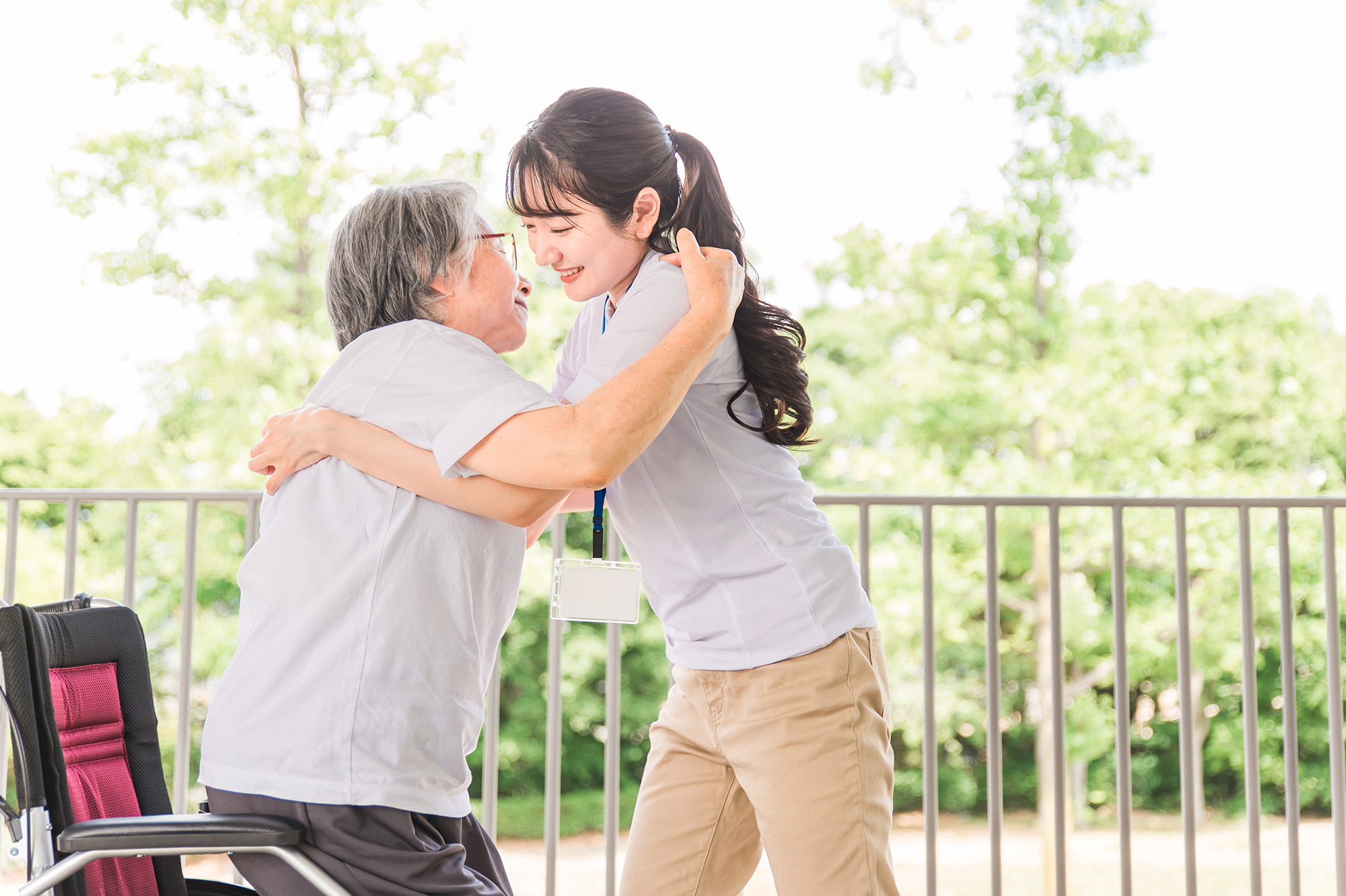 移乗・移動介助する介護士と高齢者女性