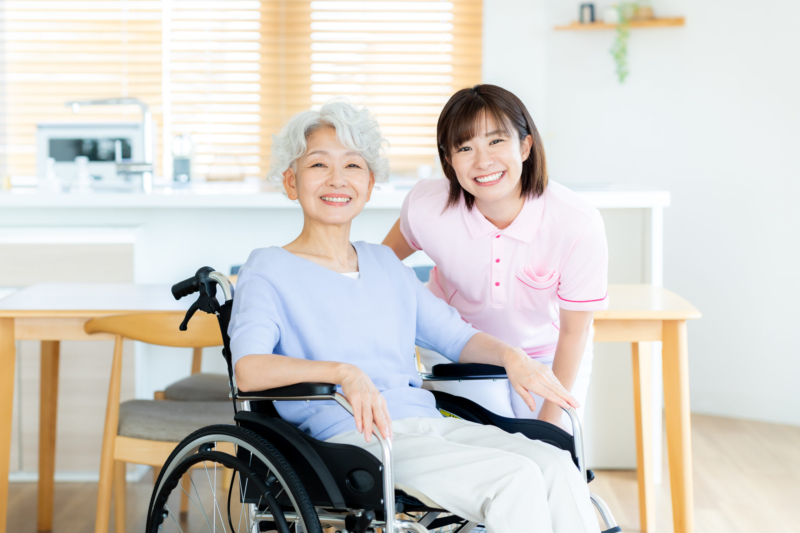 車椅子に乗った女性をサポートする介護士