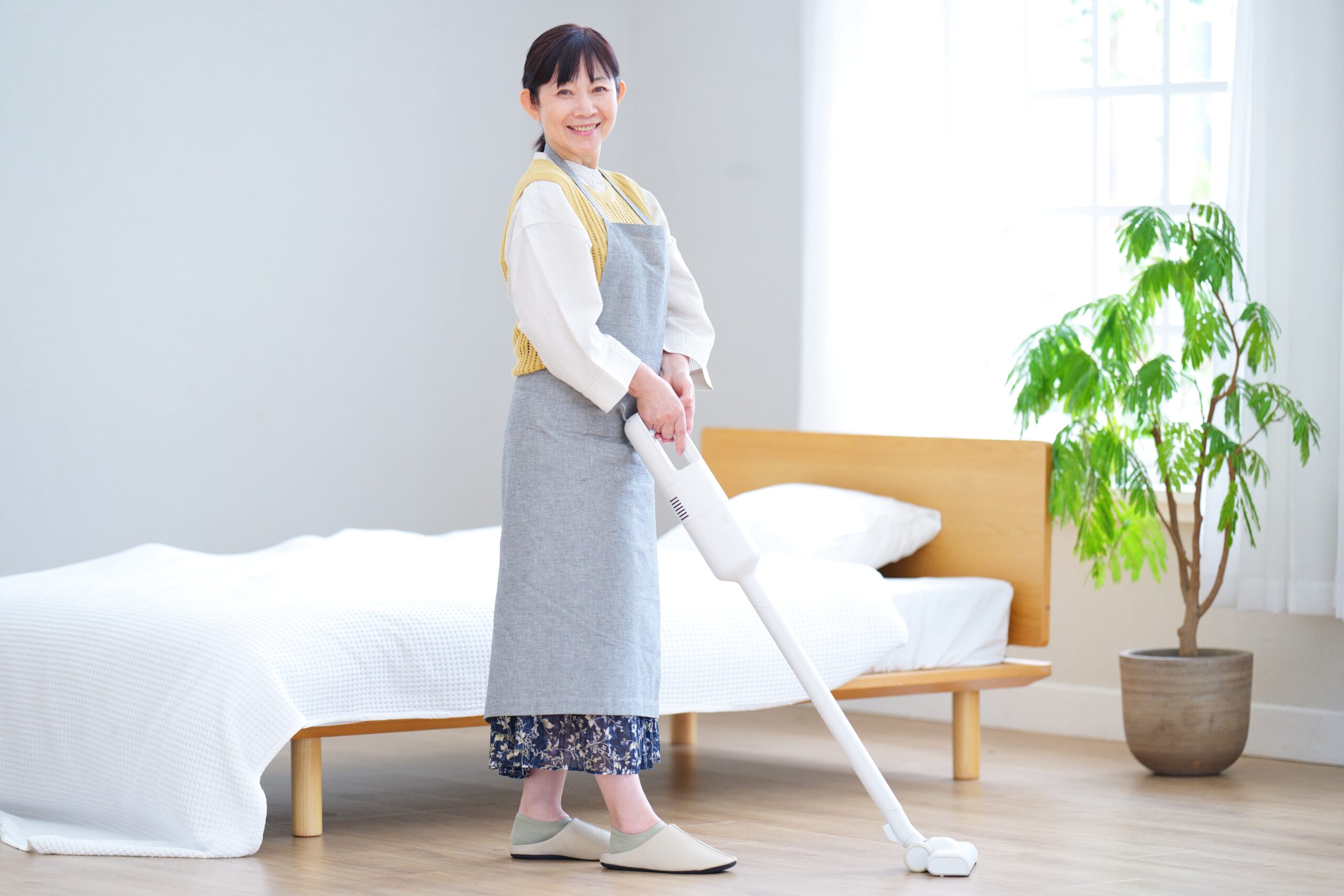 掃除中に微笑むエプロン姿の女性