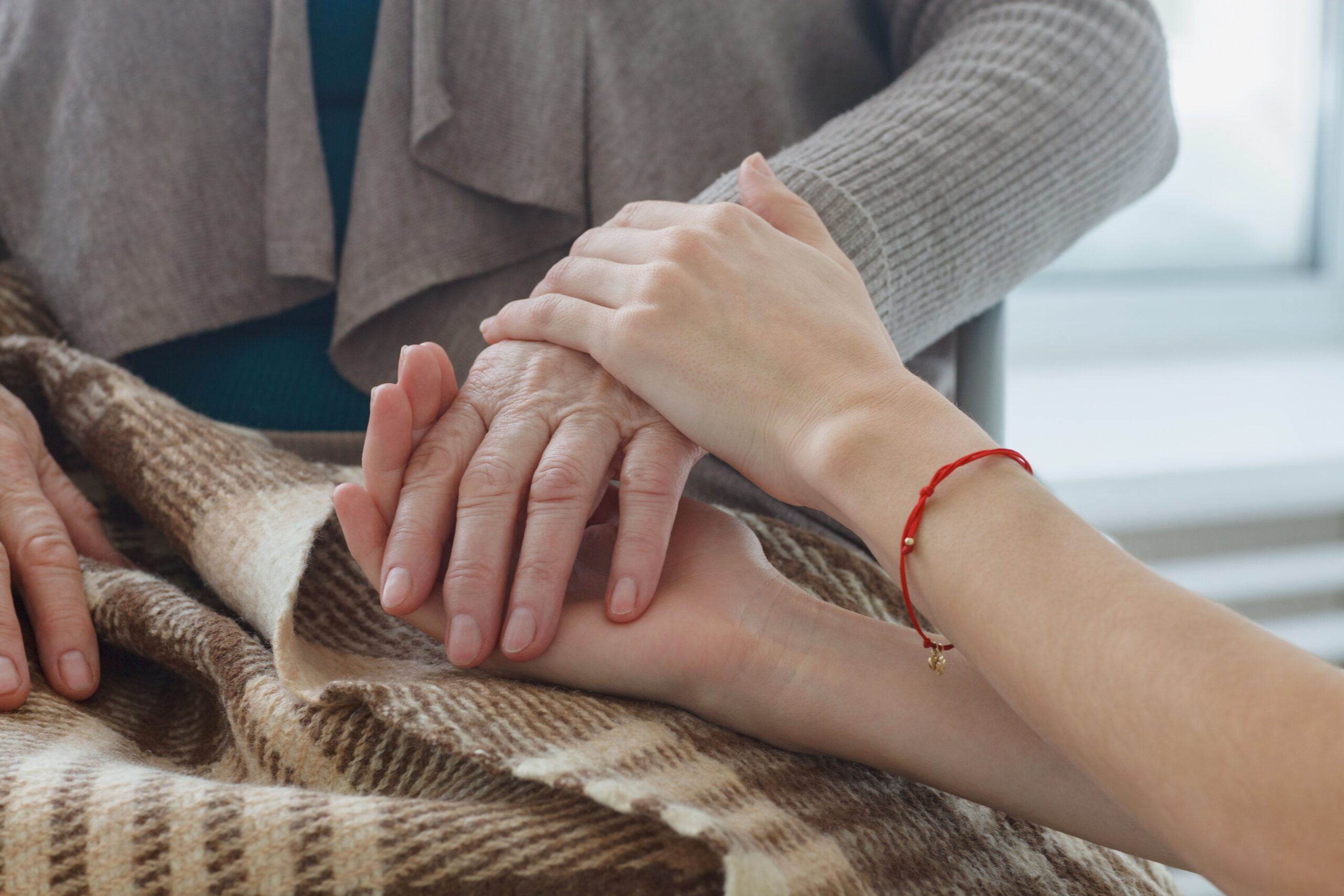 高齢者の手を握る介護士