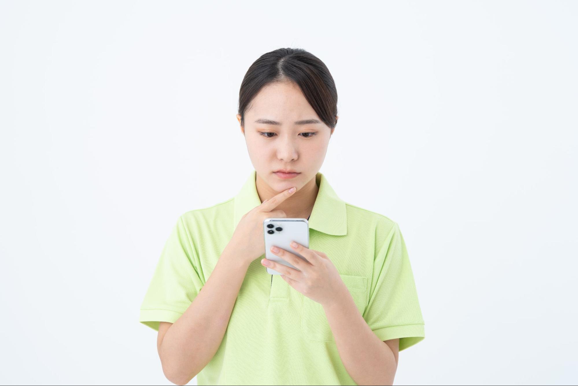 心配そうにスマホを見る介護職員