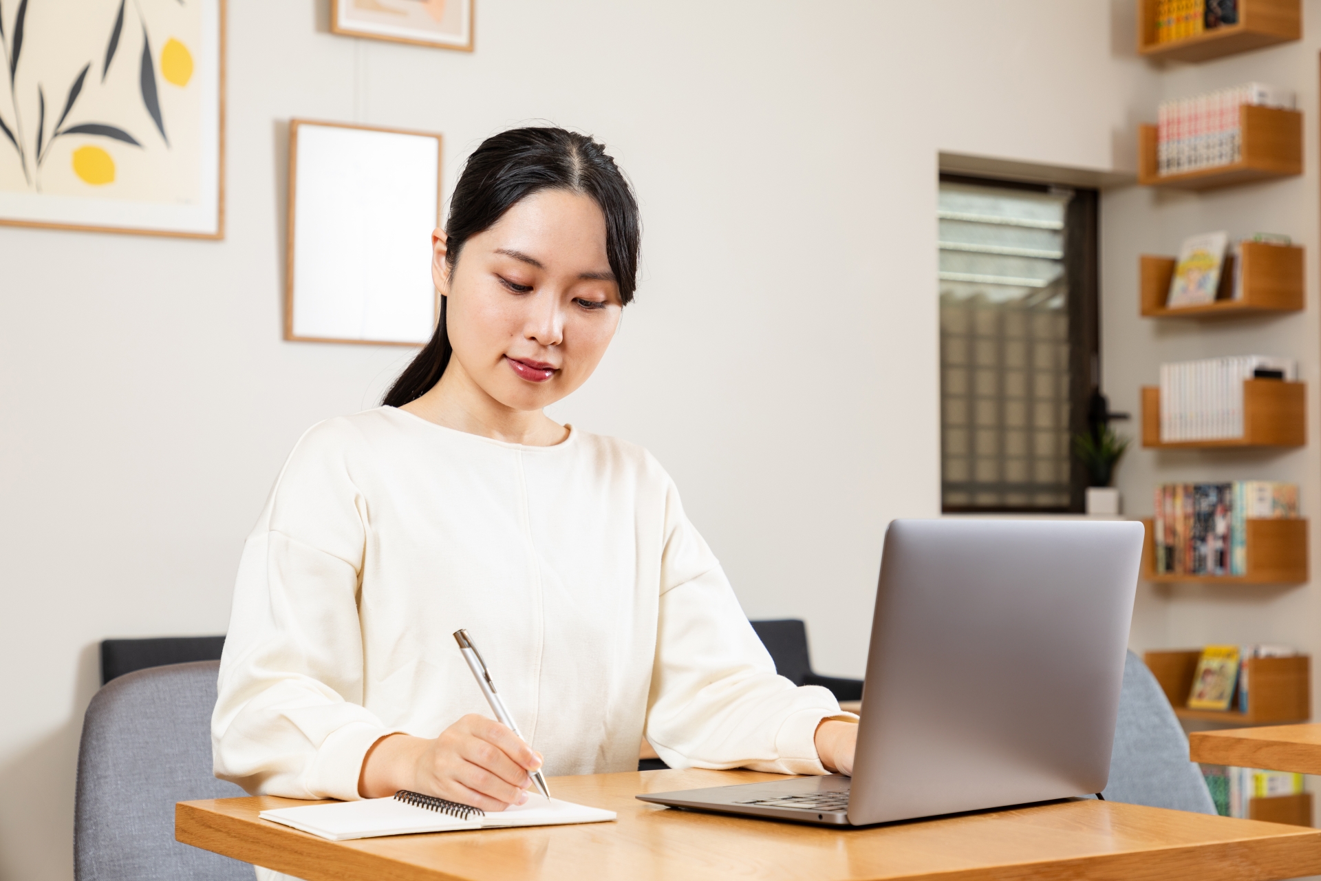 PCを操作してメモをする女性