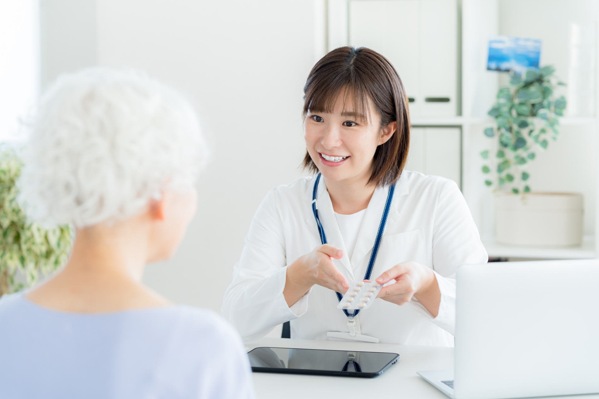 シニアに薬を渡す薬剤師