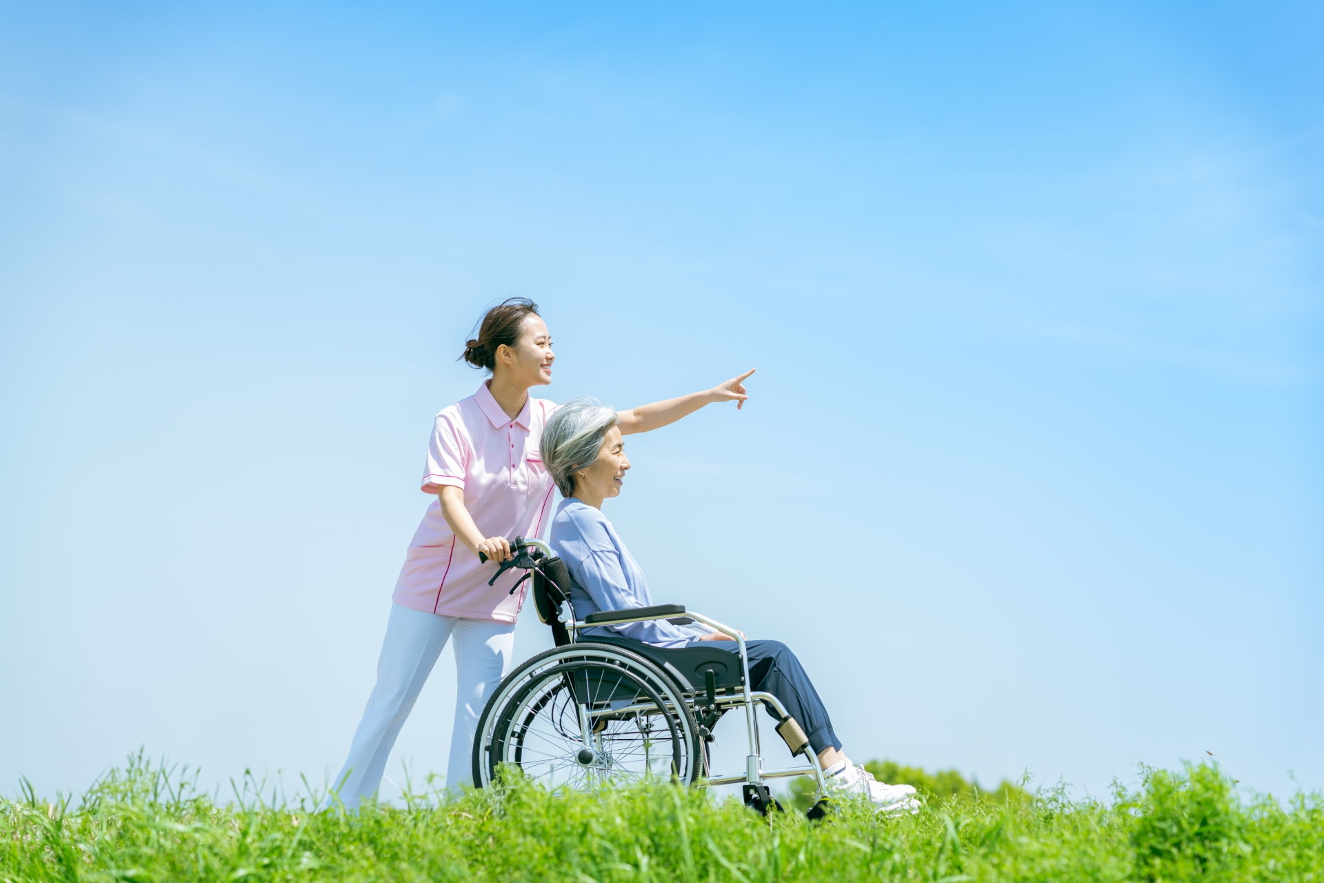 車椅子のシニアと介護士