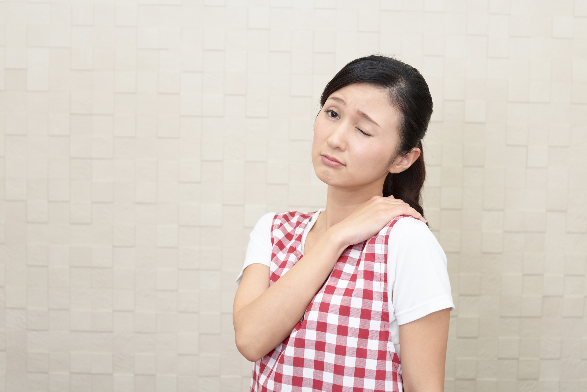 方に手を当てる女性