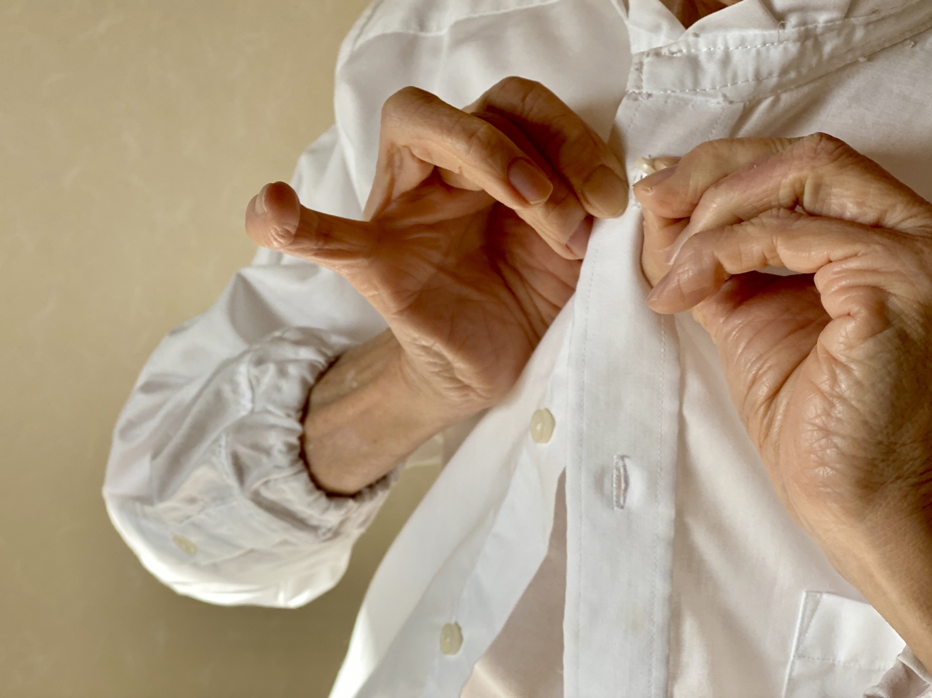 ボタンを留める高齢者