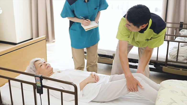 体位変換の指導を行うアジア人介護士