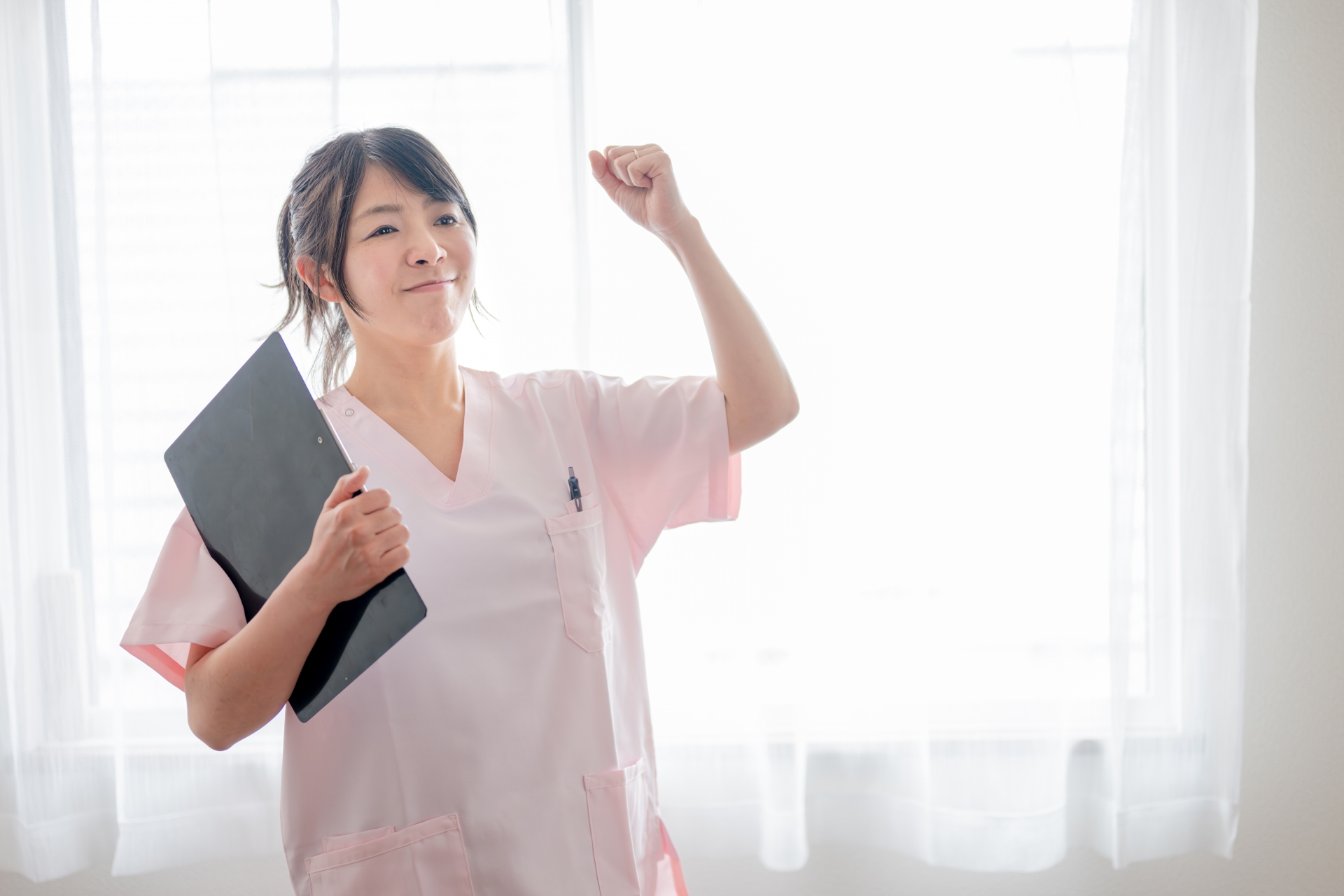 ガッツポーズする若い医療女性