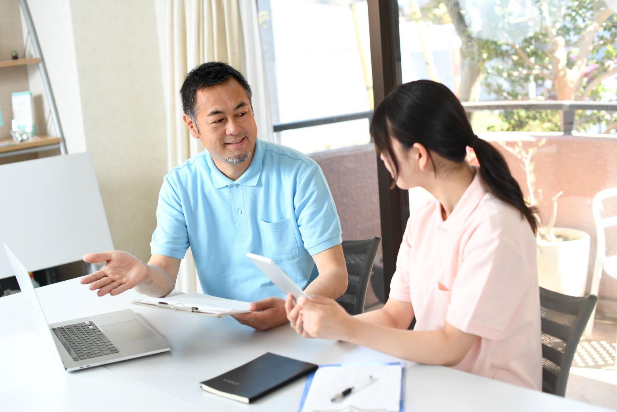 打ち合わせ中の介護士の男女