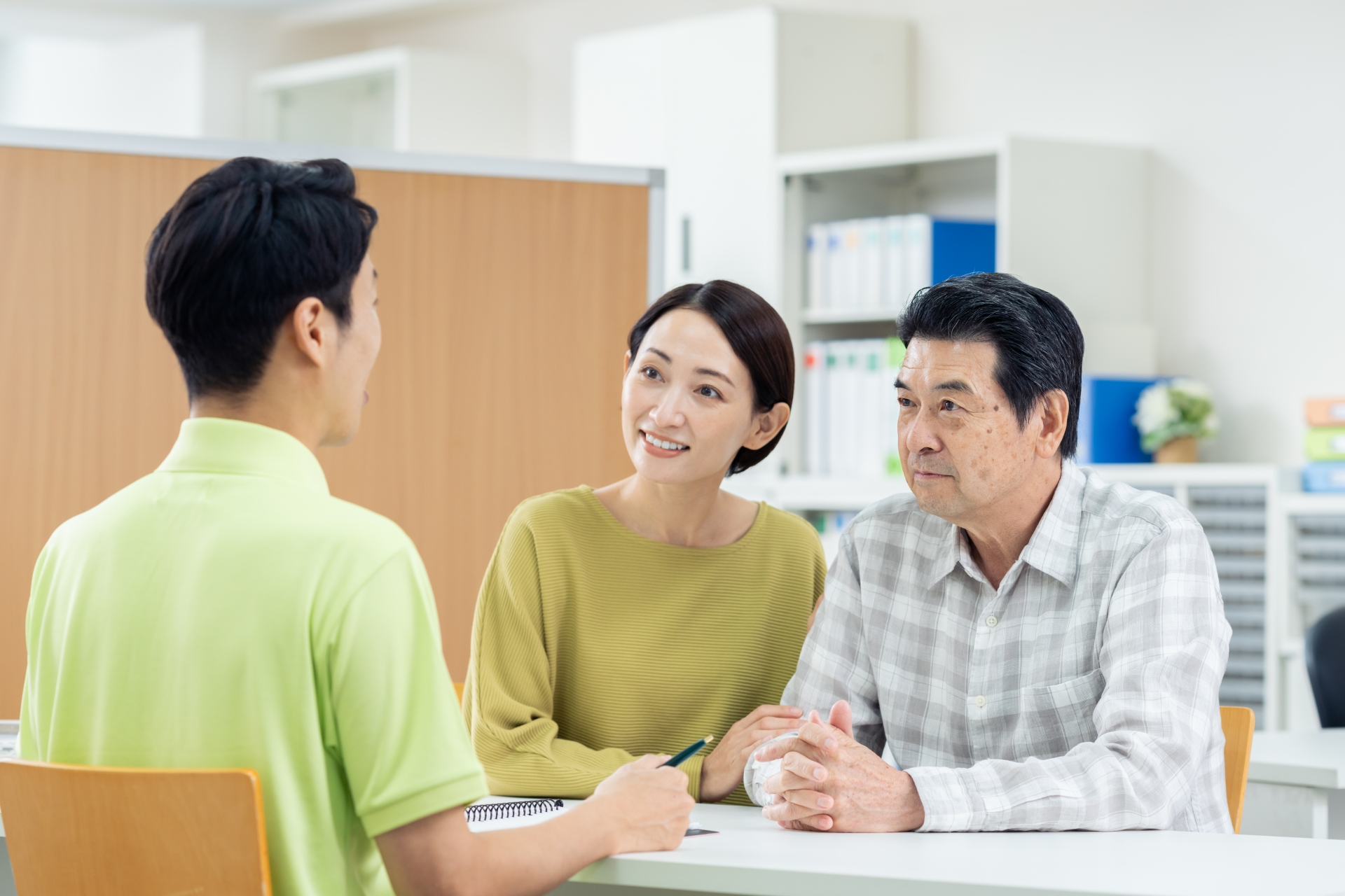 家族と打ち合わせする介護士