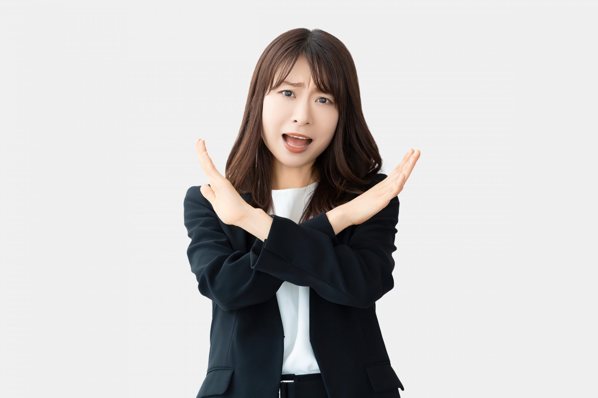 手でバツのポーズをして怒る女性