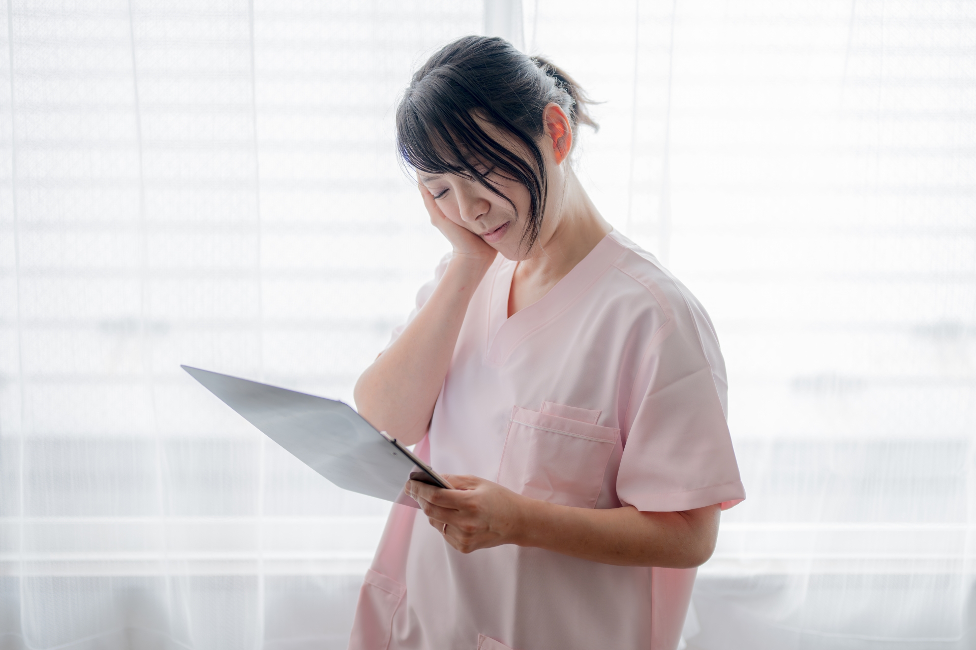 頬に手を当てる医療系女性