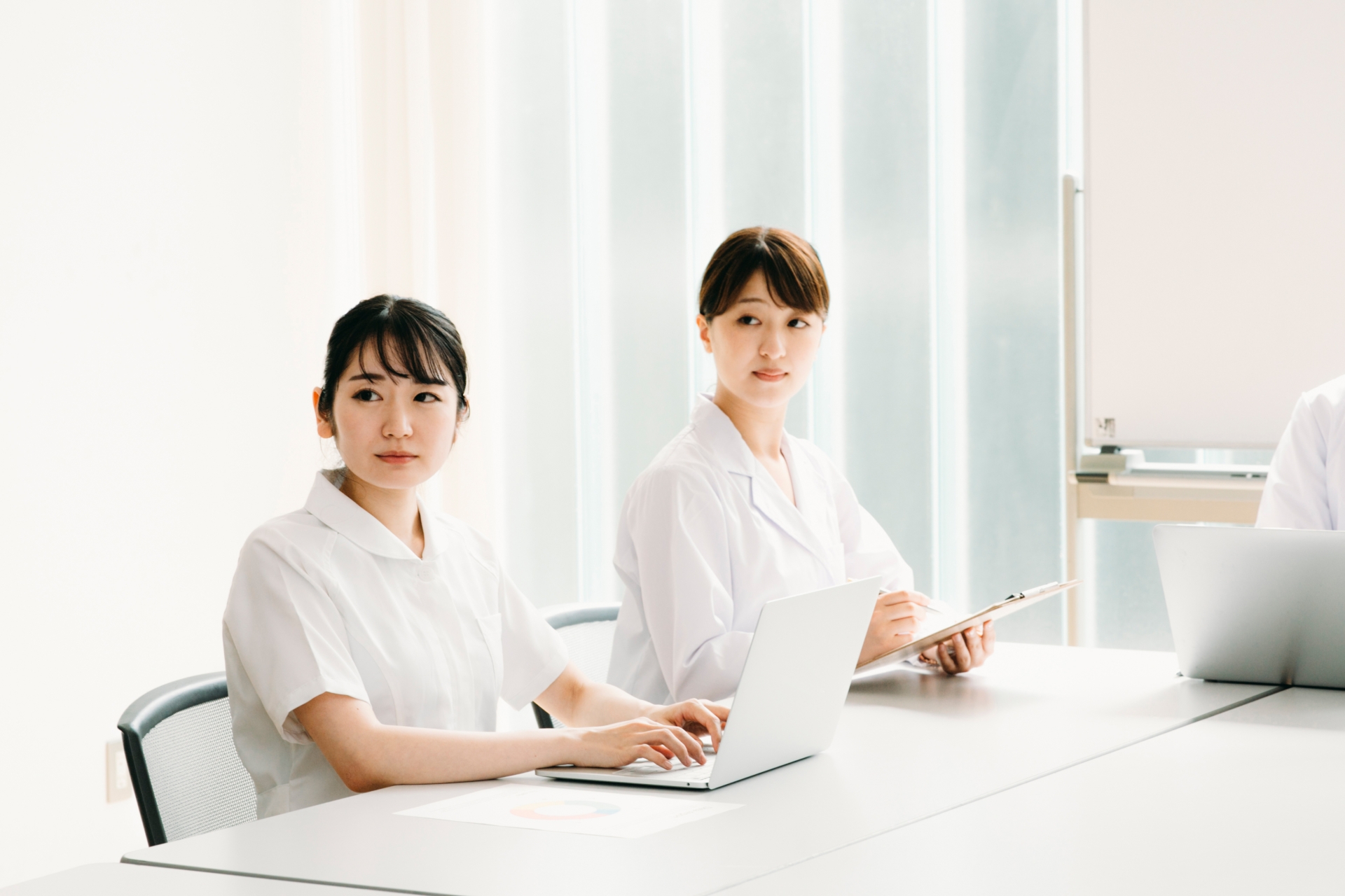 会議する白衣姿の女性