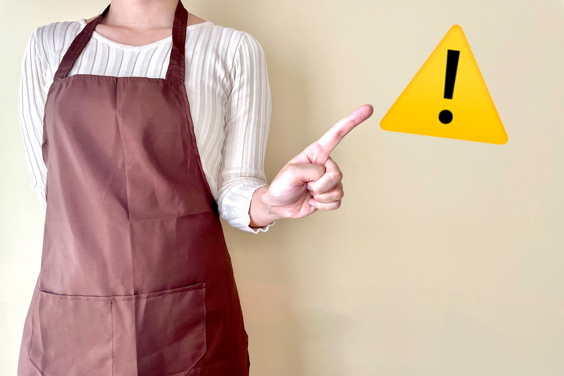 注意マークを指差す女性