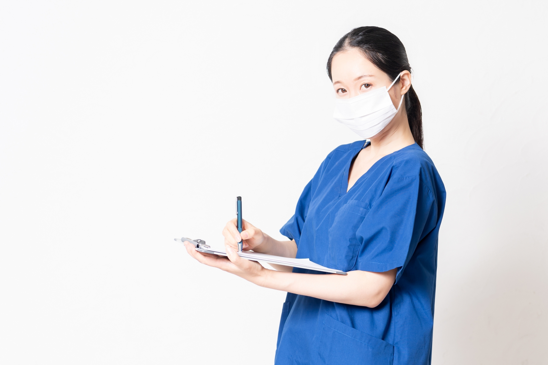 問診をしながらカルテに記入するマスクをした医療従事者