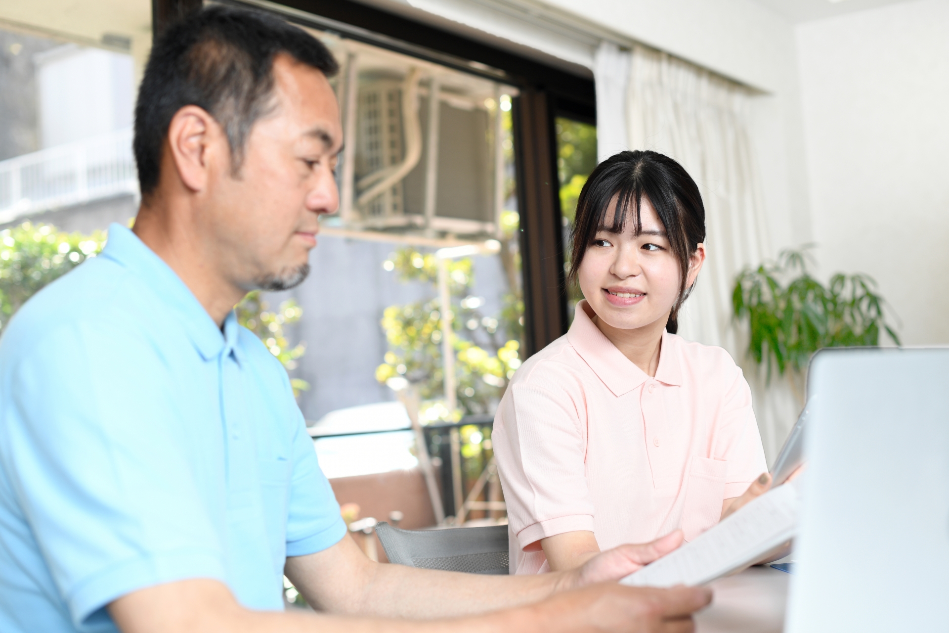 ベテラン介護士と話をする若い介護士