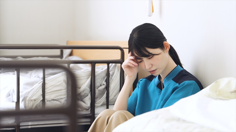 介護の仕事で疲れるアジア人介護士