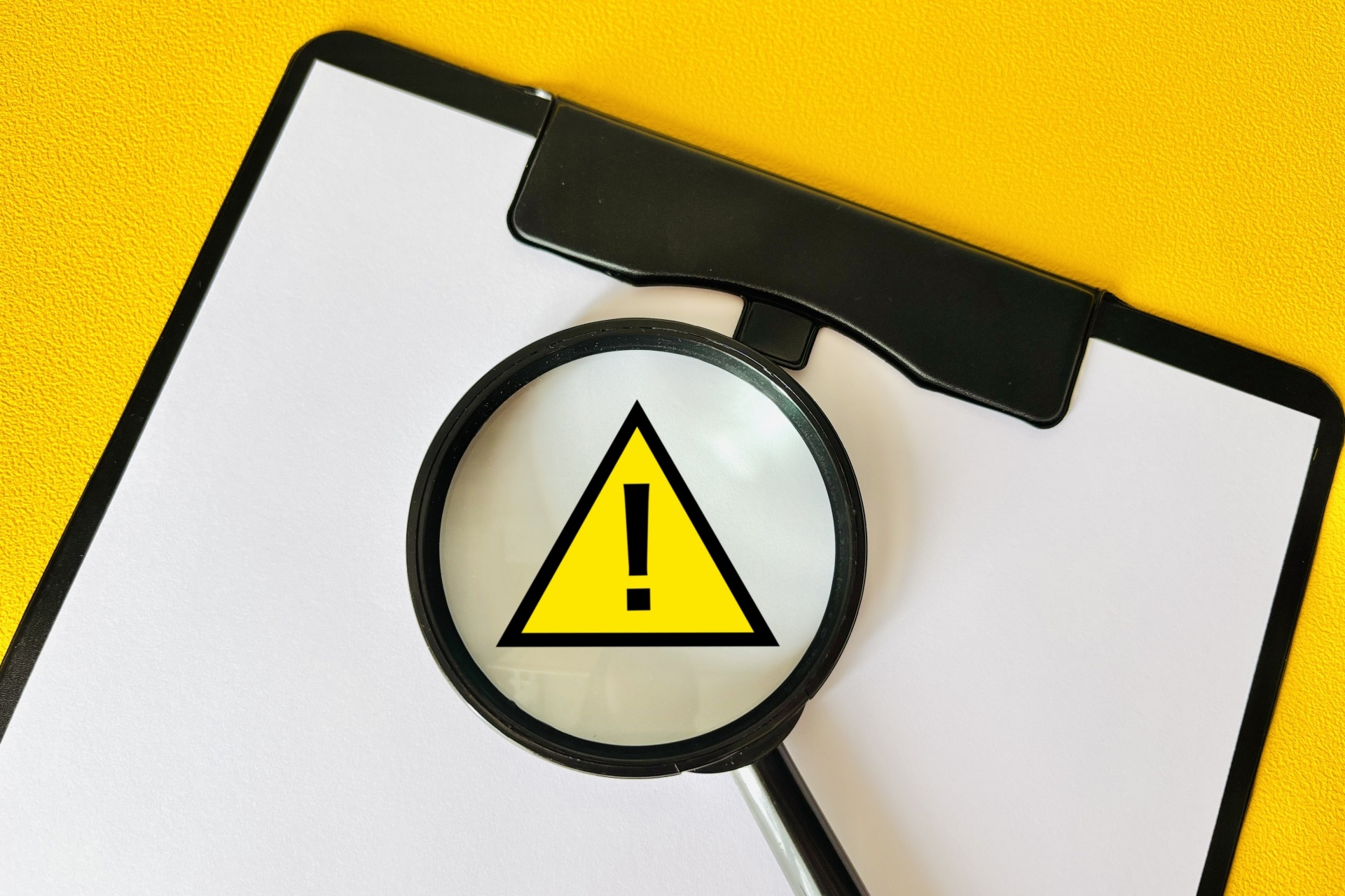 虫眼鏡と注意マーク