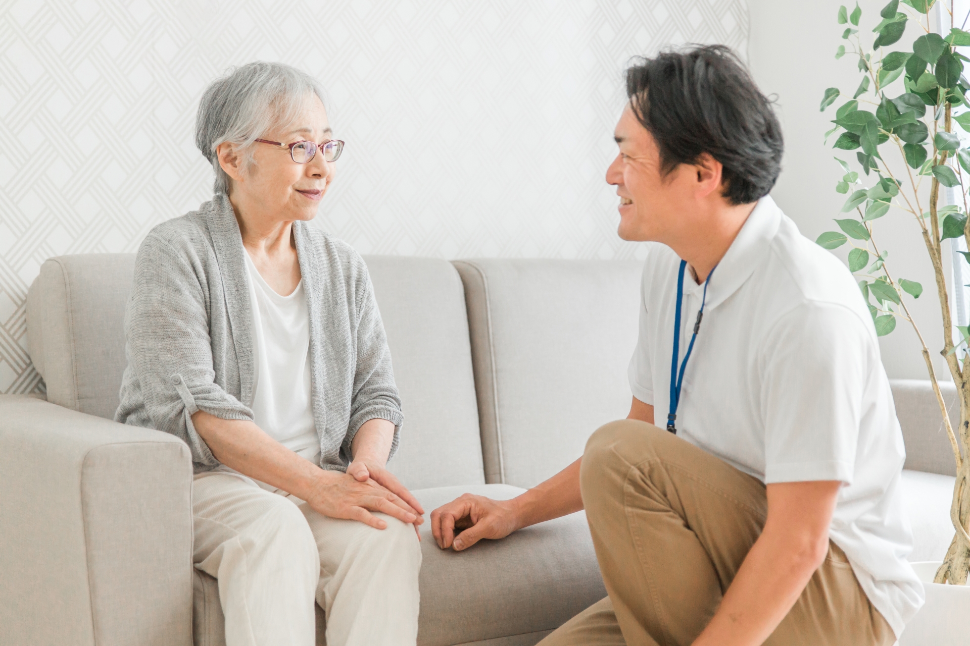 男性介護士と話をする高齢女性