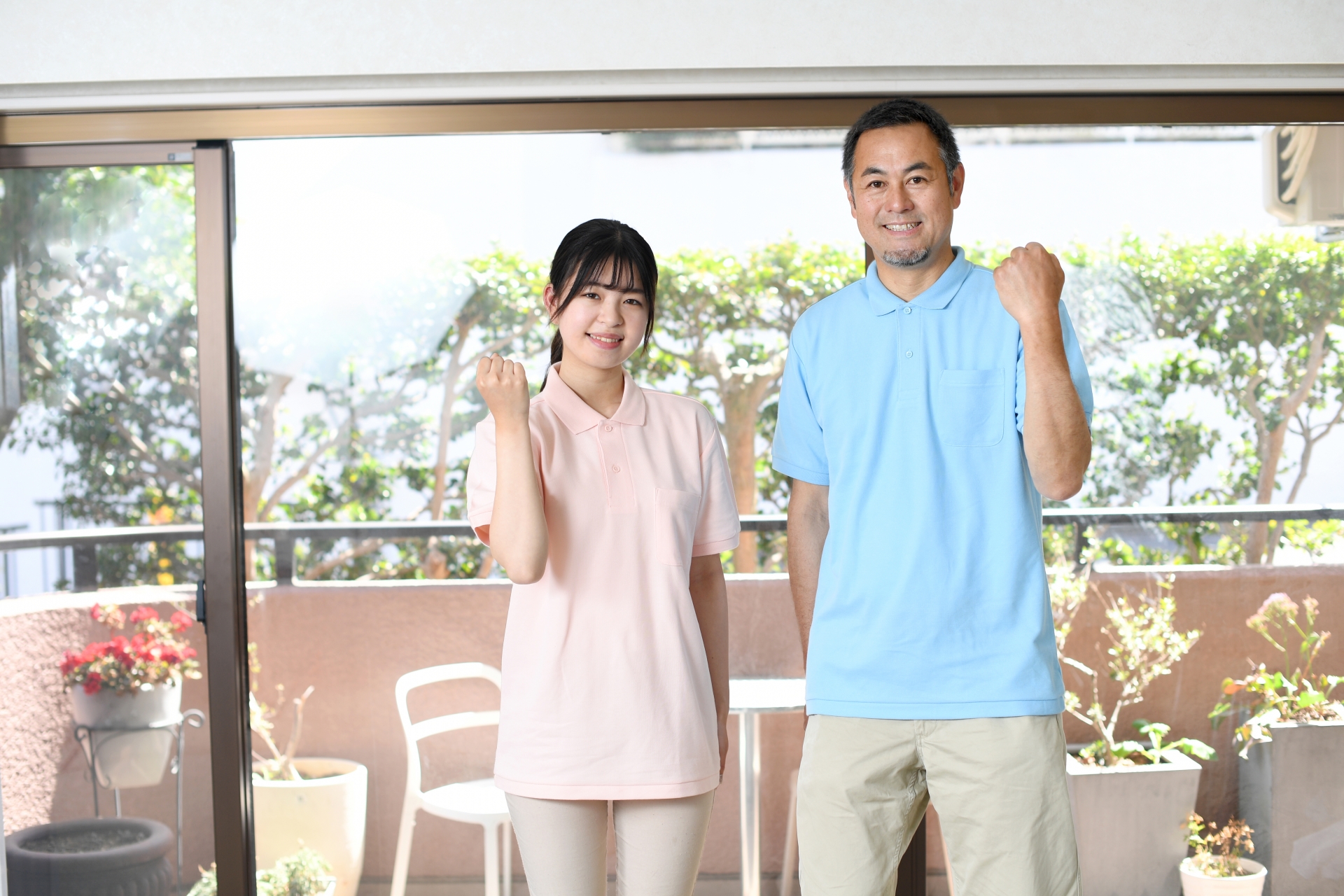 ガッツポーズをする男女の介護士