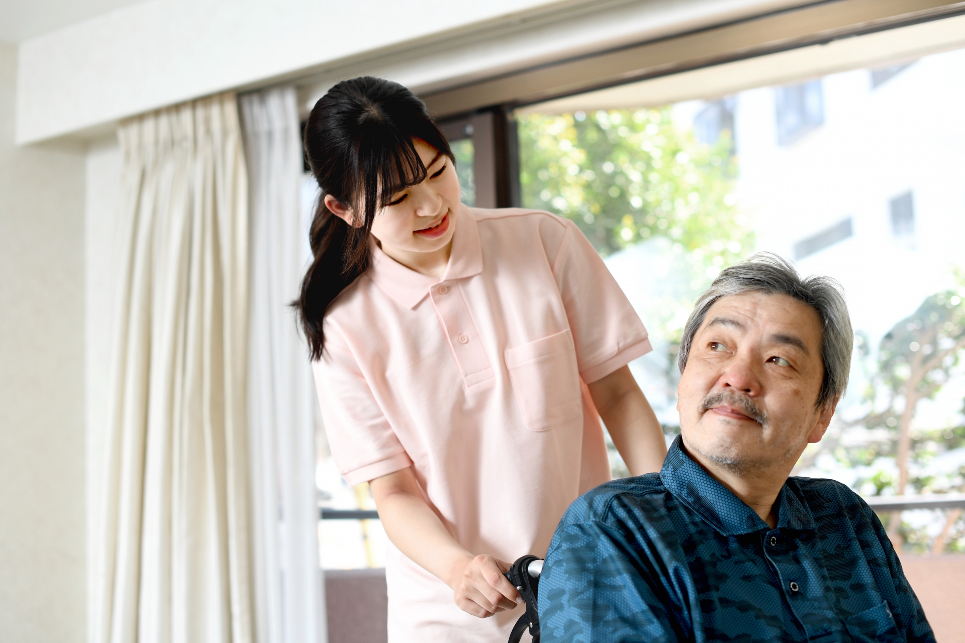 高齢者と車椅子を押す女性介護士