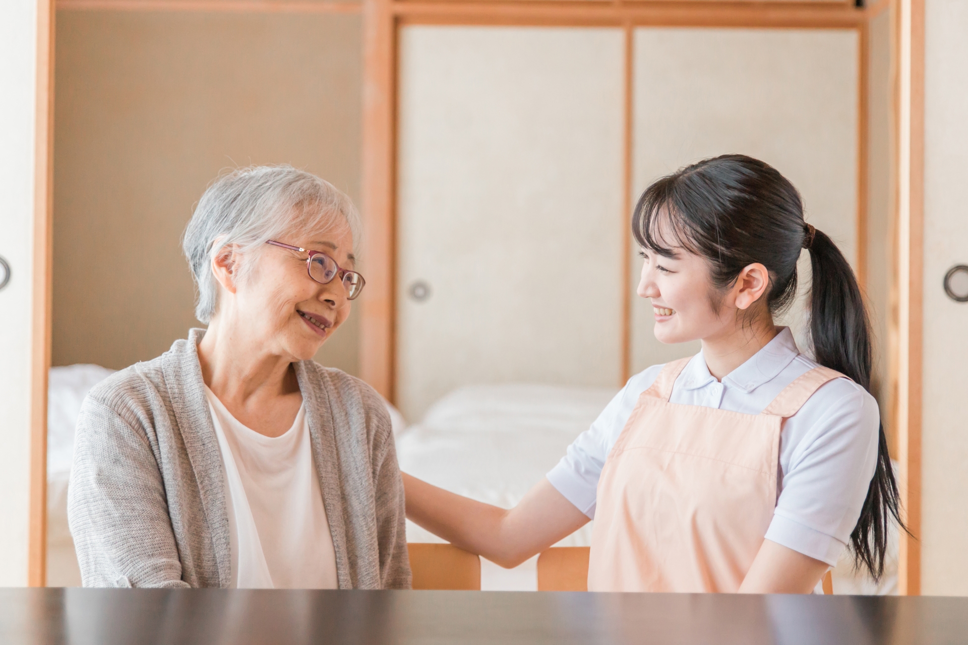 高齢者女性と話す女性スタッフ