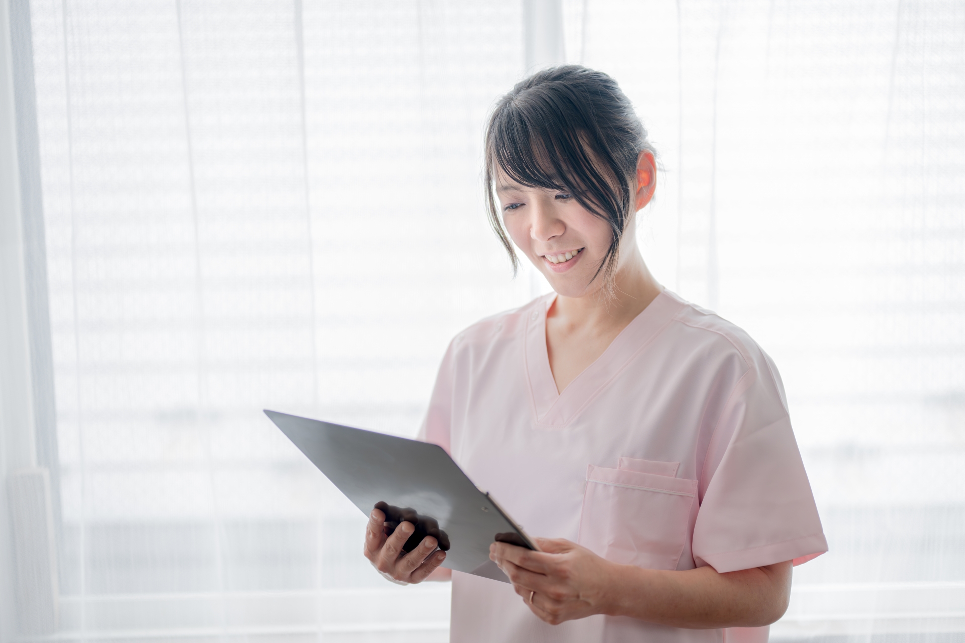書面を見て笑顔の医療系女性