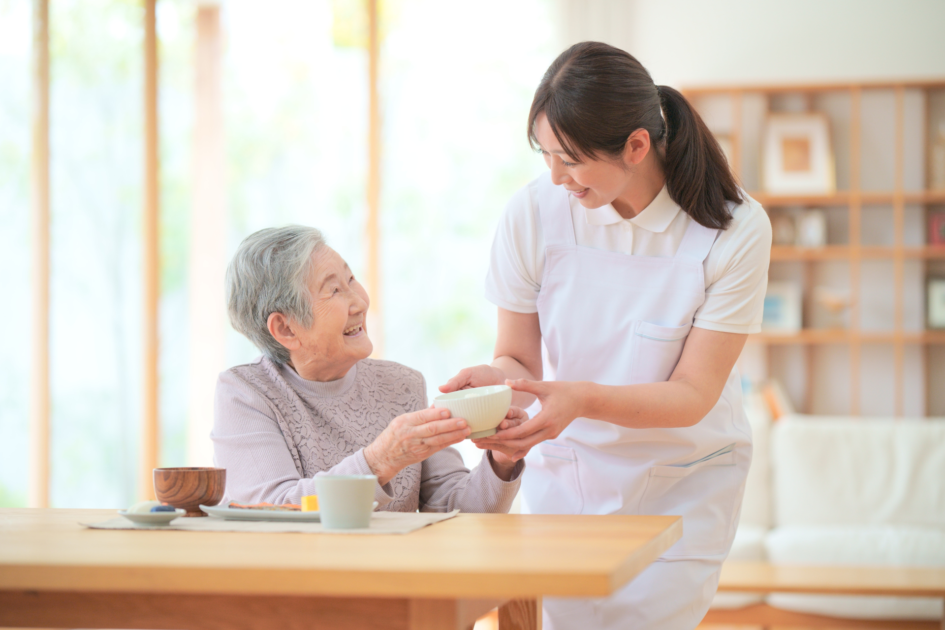 茶碗を持つ笑顔の高齢女性