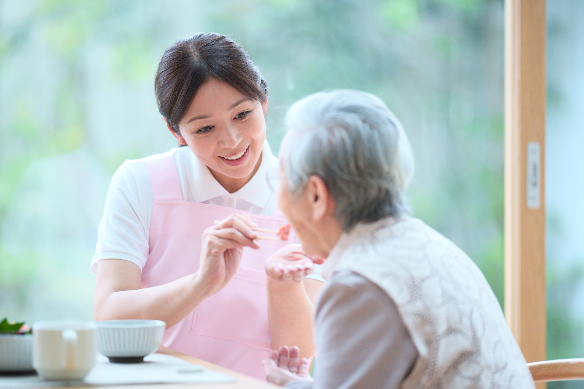 高齢者に食べさせている女性