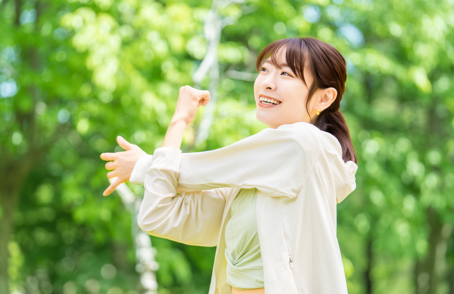 緑の中でストレッチをする女性