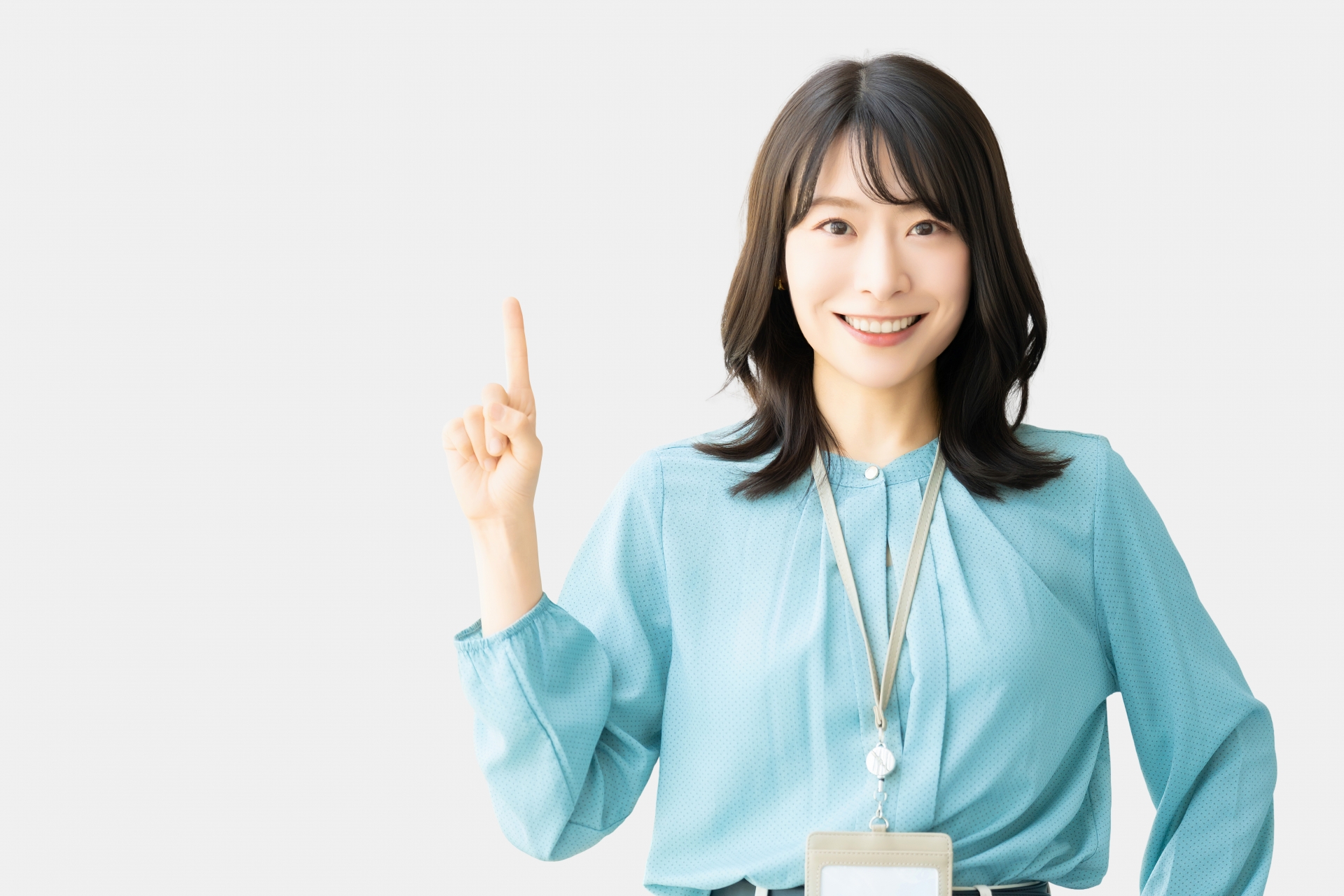 人差し指を立てて案内するビジネスウーマン