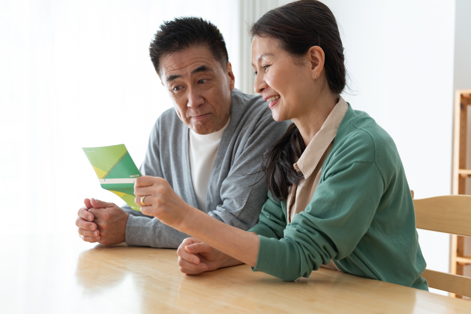 通帳を持つ笑顔の夫婦