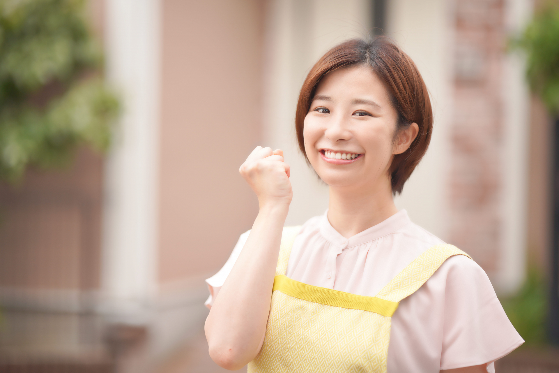 片手でガッツポーズをする笑顔のエプロンの女性