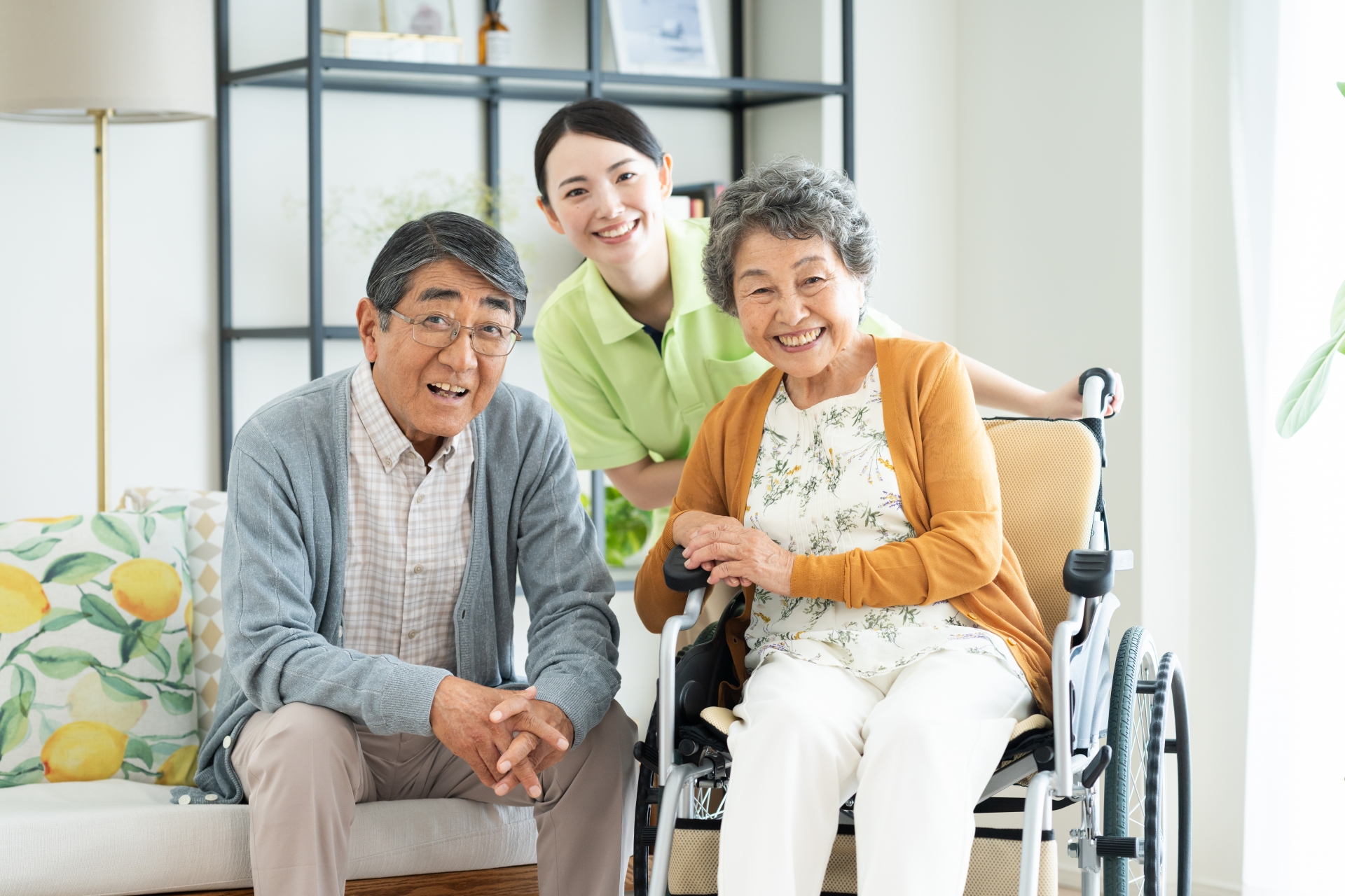 車椅子のシニアの夫婦と介護福祉士