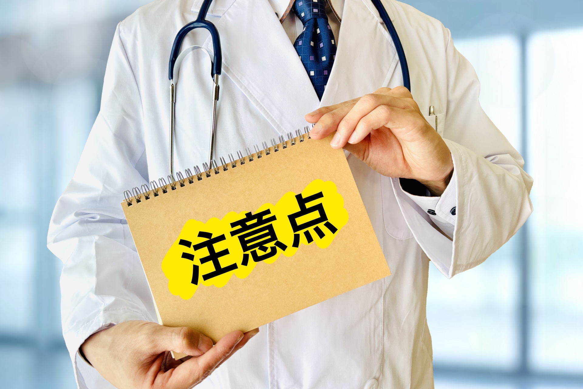 注意点のノートを持つ医師