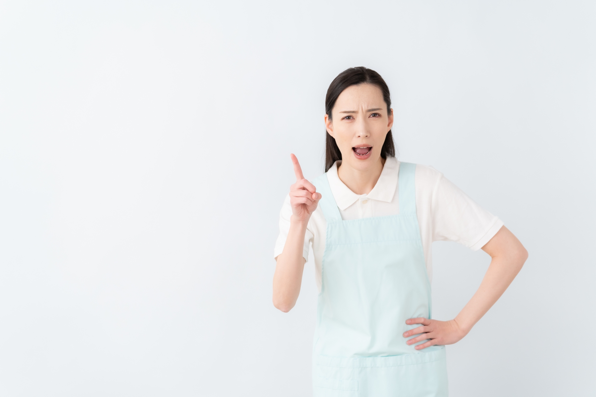 指を立てて叱る動作をするエプロン姿の女性