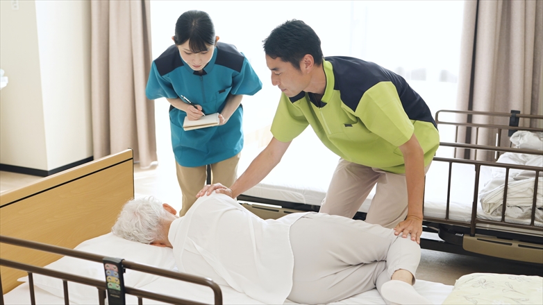 体位変換の指導を行う介護士